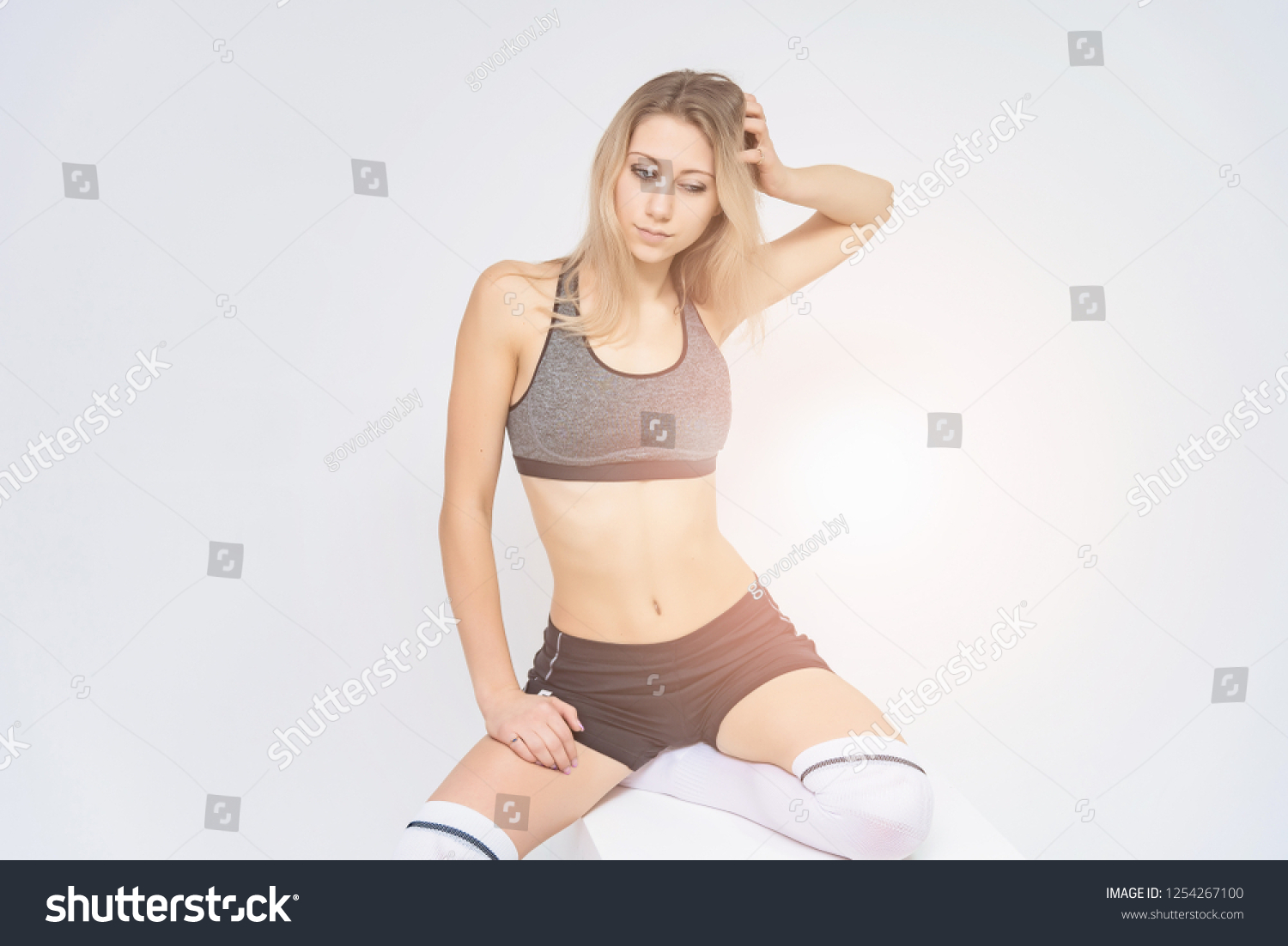 Concept portrait of a beautiful fitness girl blonde smiling on a white background advertisement. #1254267100