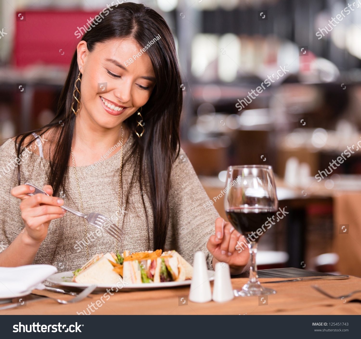 Woman eating at a restaurant looking very happy #125451743