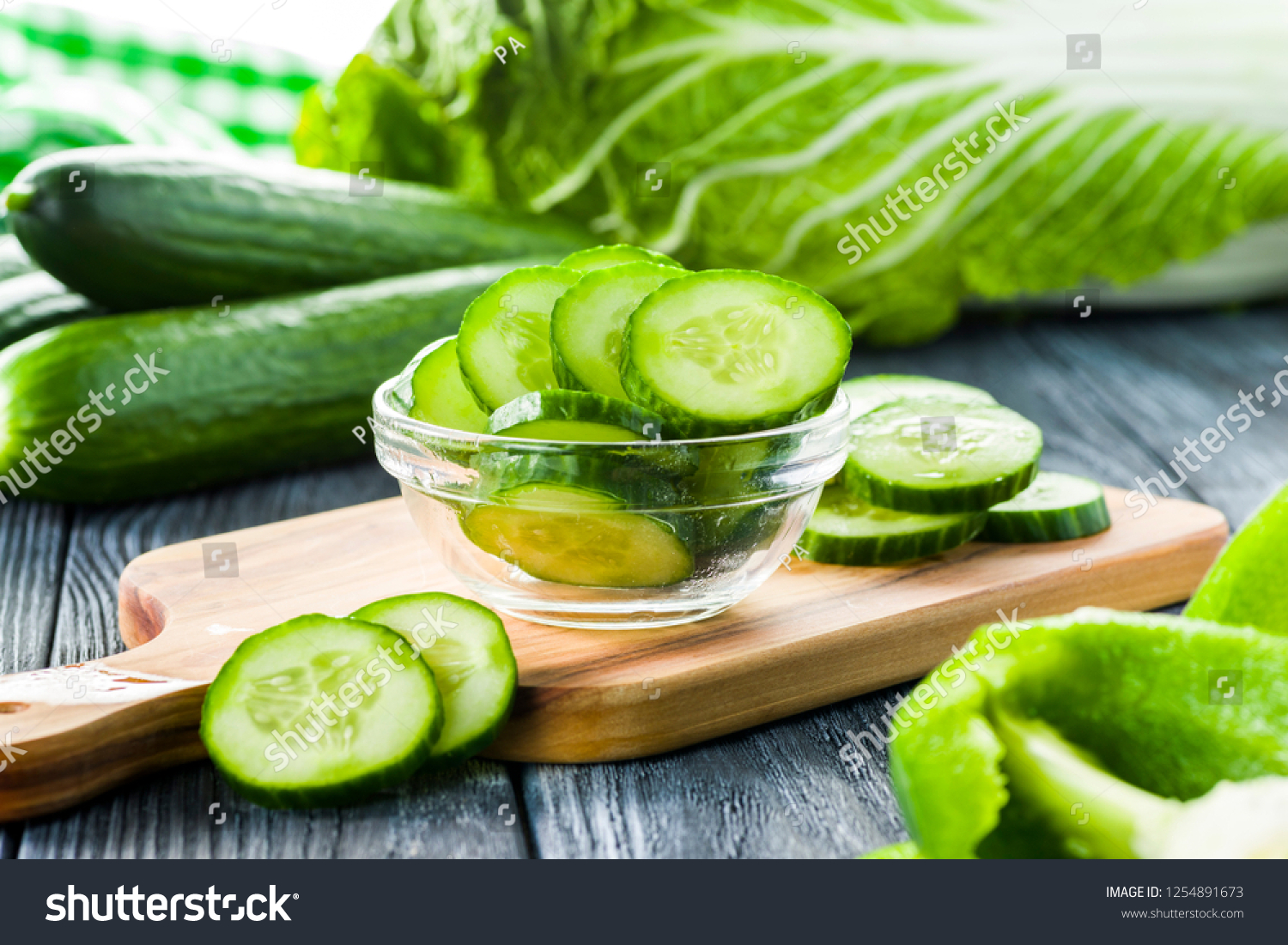 fresh cucumber sliced in a plate on table #1254891673