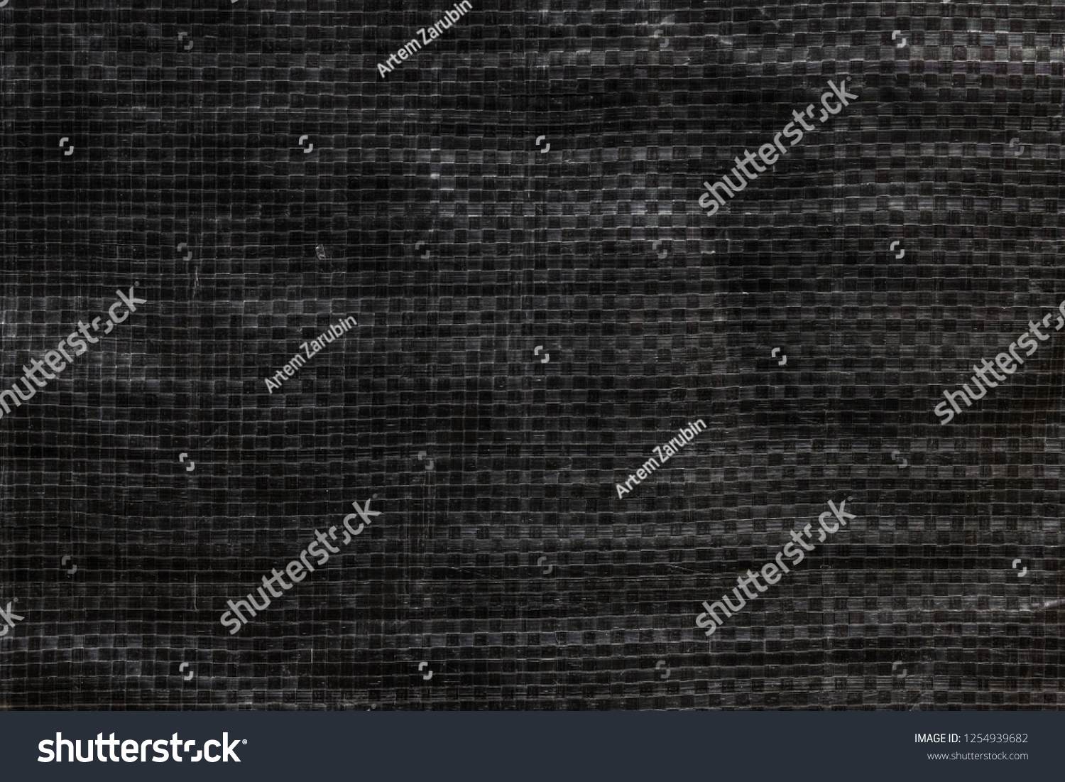 The texture of black polyethylene woven fabric. Abstract dark background of synthetic polypropylene or polyethylene (PP, PE) material which used as outdoor tarpaulin #1254939682