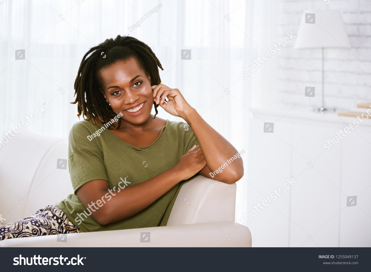 Portrait of attractive smiling Vietnamese woman resting on comfy sofa at home #1255049137