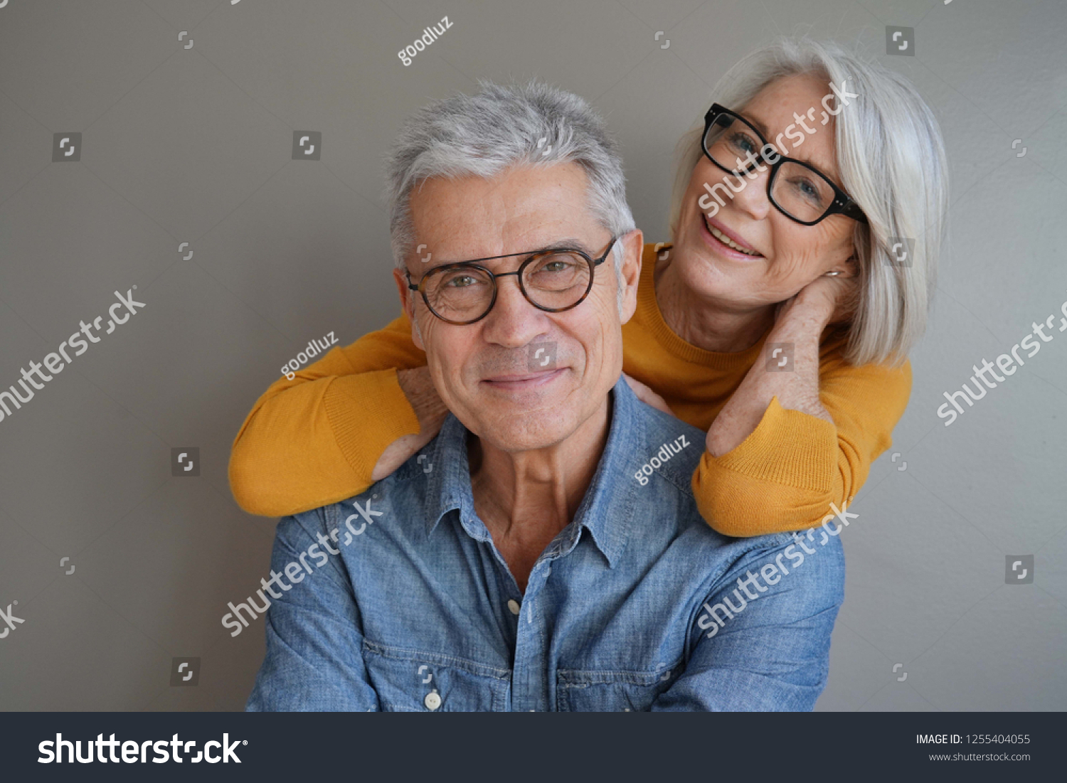  Portrait of relaxed fun senior couple wearing glasses on background                               #1255404055