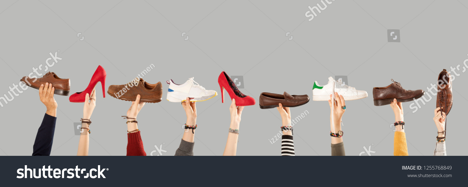 many shoes on arm raised hands #1255768849