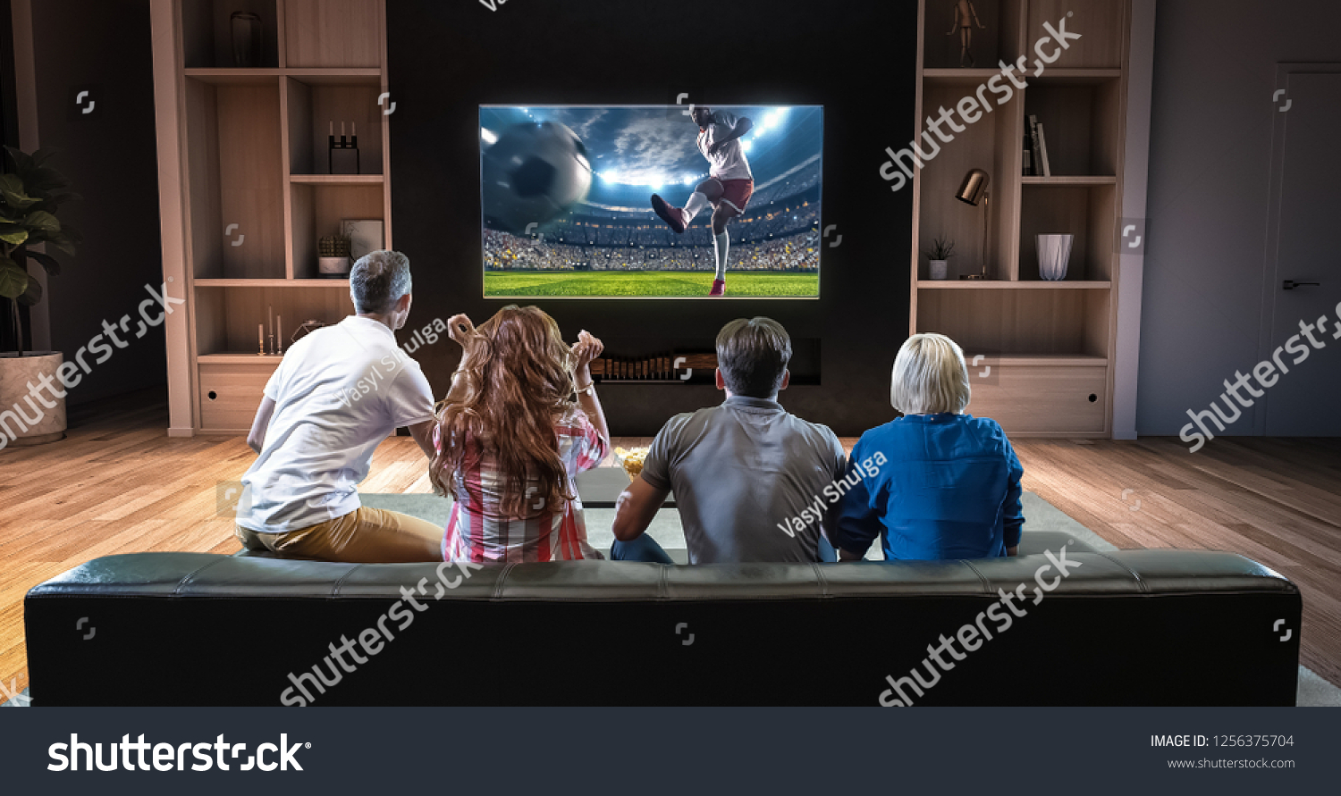 Group of students are watching a soccer moment on the TV and celebrating a goal, sitting on the couch in the living room. The living room is made in 3D. #1256375704