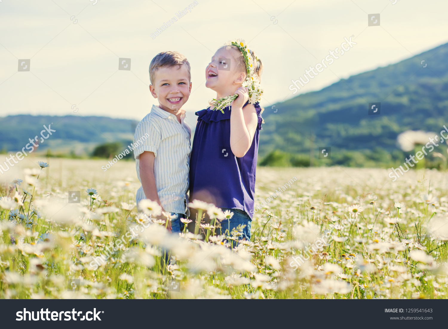Lovely little children in the field of daisies. #1259541643