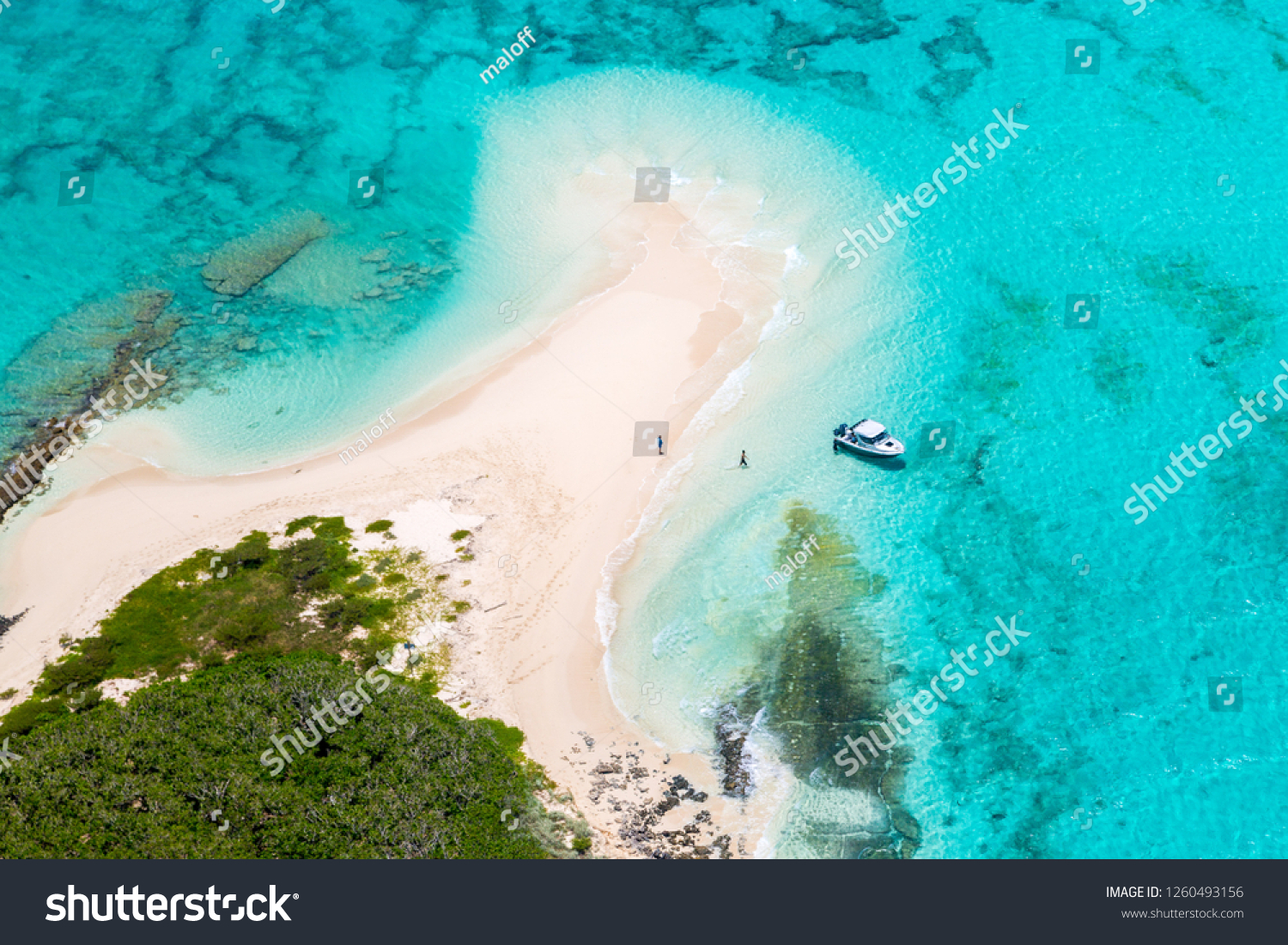 Tourists, divers, snorkelers, jet boat, an idyllic empty sandy beach of remote island, azure turquoise blue lagoon, West Coast barrier reef, aerial view. New Caledonia, Melanesia, South Pacific Ocean. #1260493156