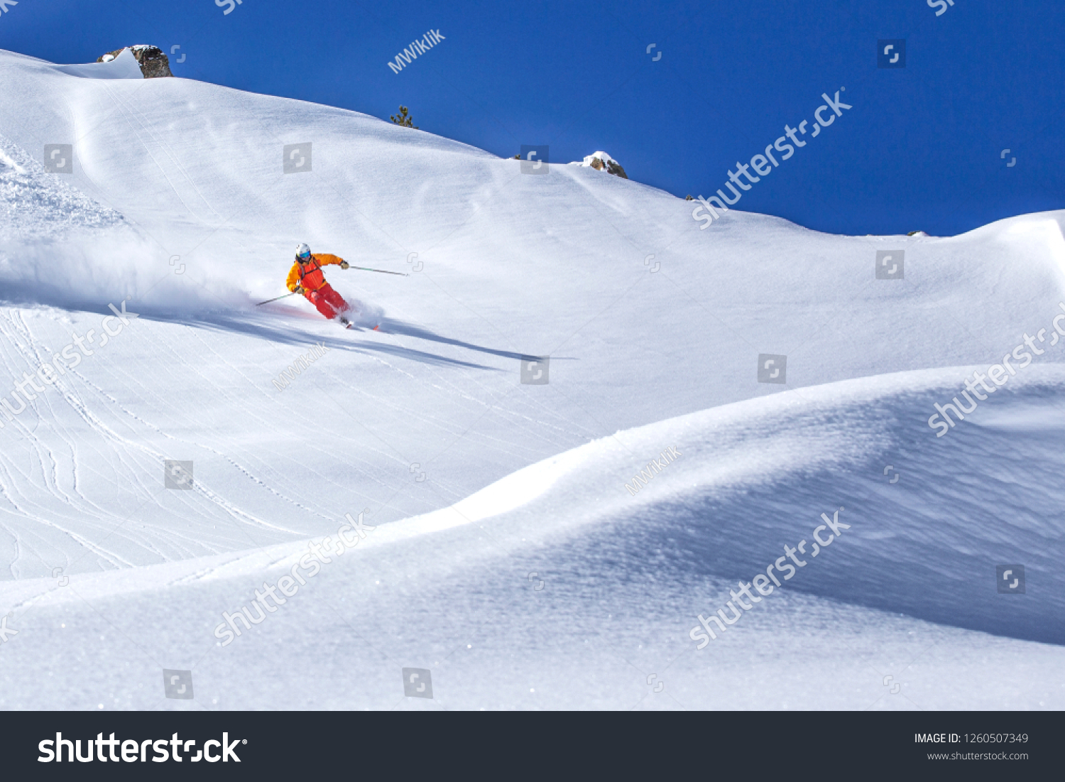 freeride skier skiing downhill through fresh powder snow #1260507349