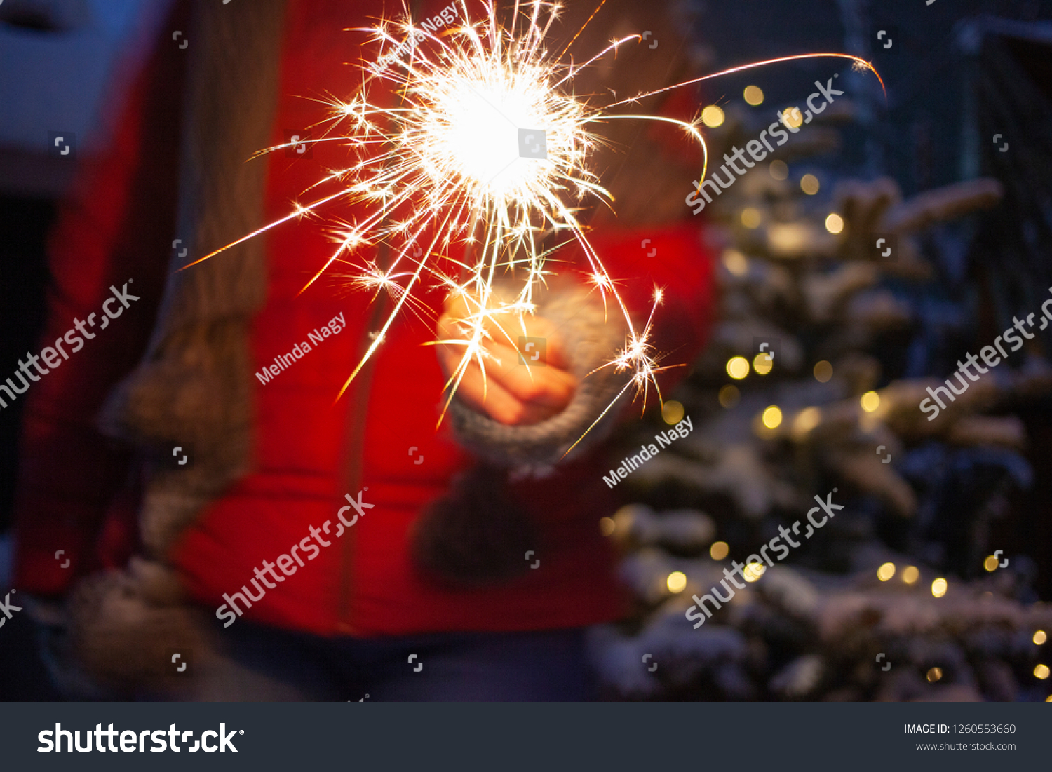 woman holding sparkles on a winter night - happy new year #1260553660