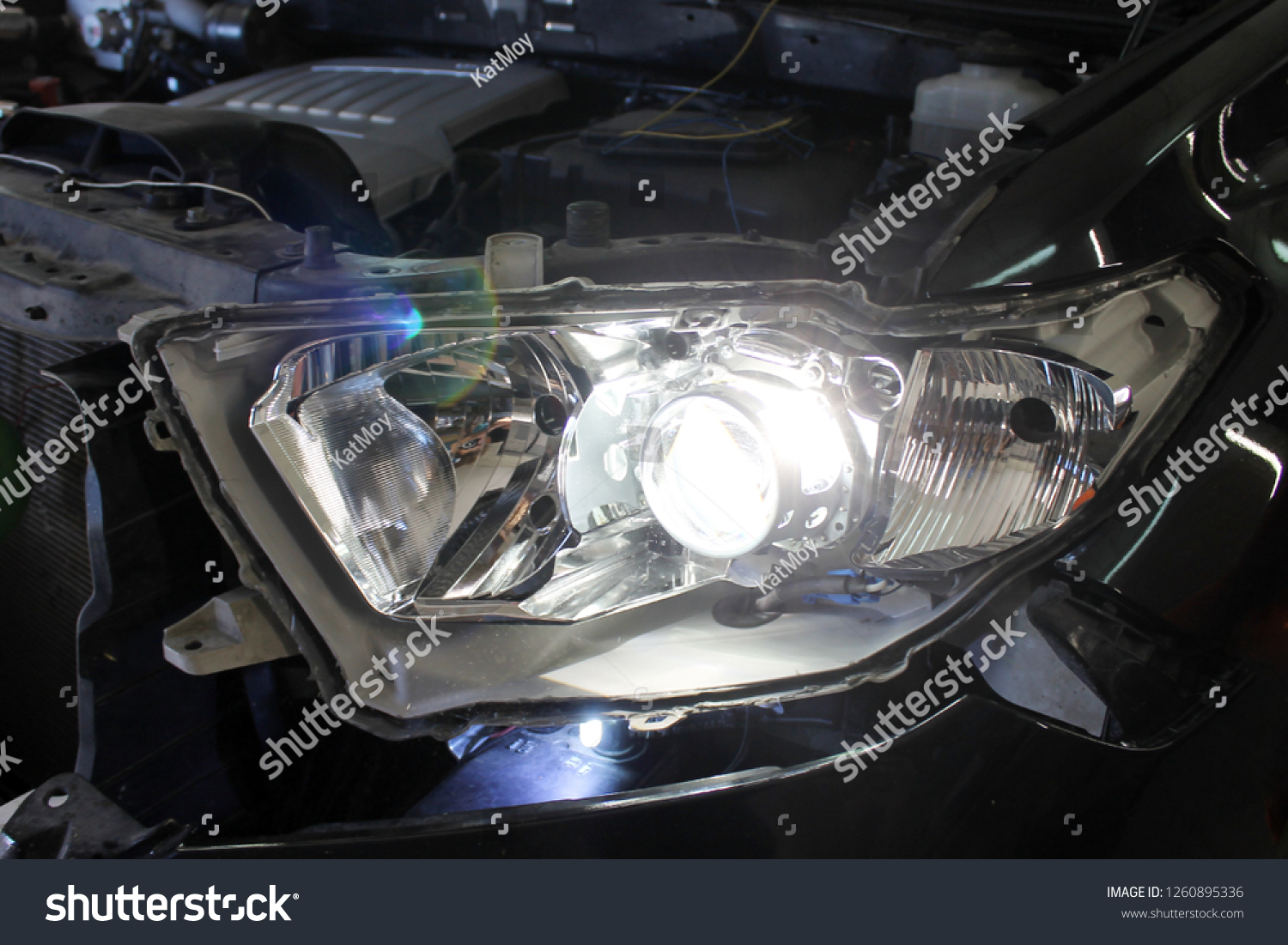 Close up view of repairing, installation and tuning headlight of modern automobile and car projector lens. Vehicle head xenon lamp in details. Concept of auto detailing, light and LED technology #1260895336