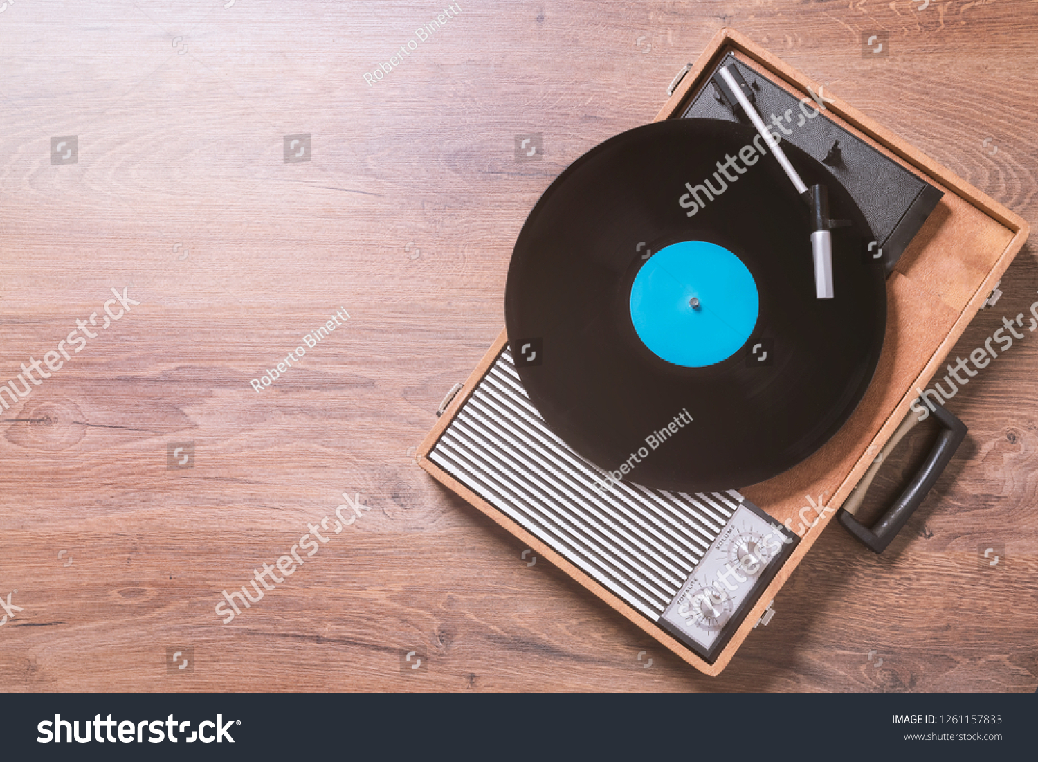 Older Gramophone with a vinyl record on wooden table, top view and copy space,photo. #1261157833