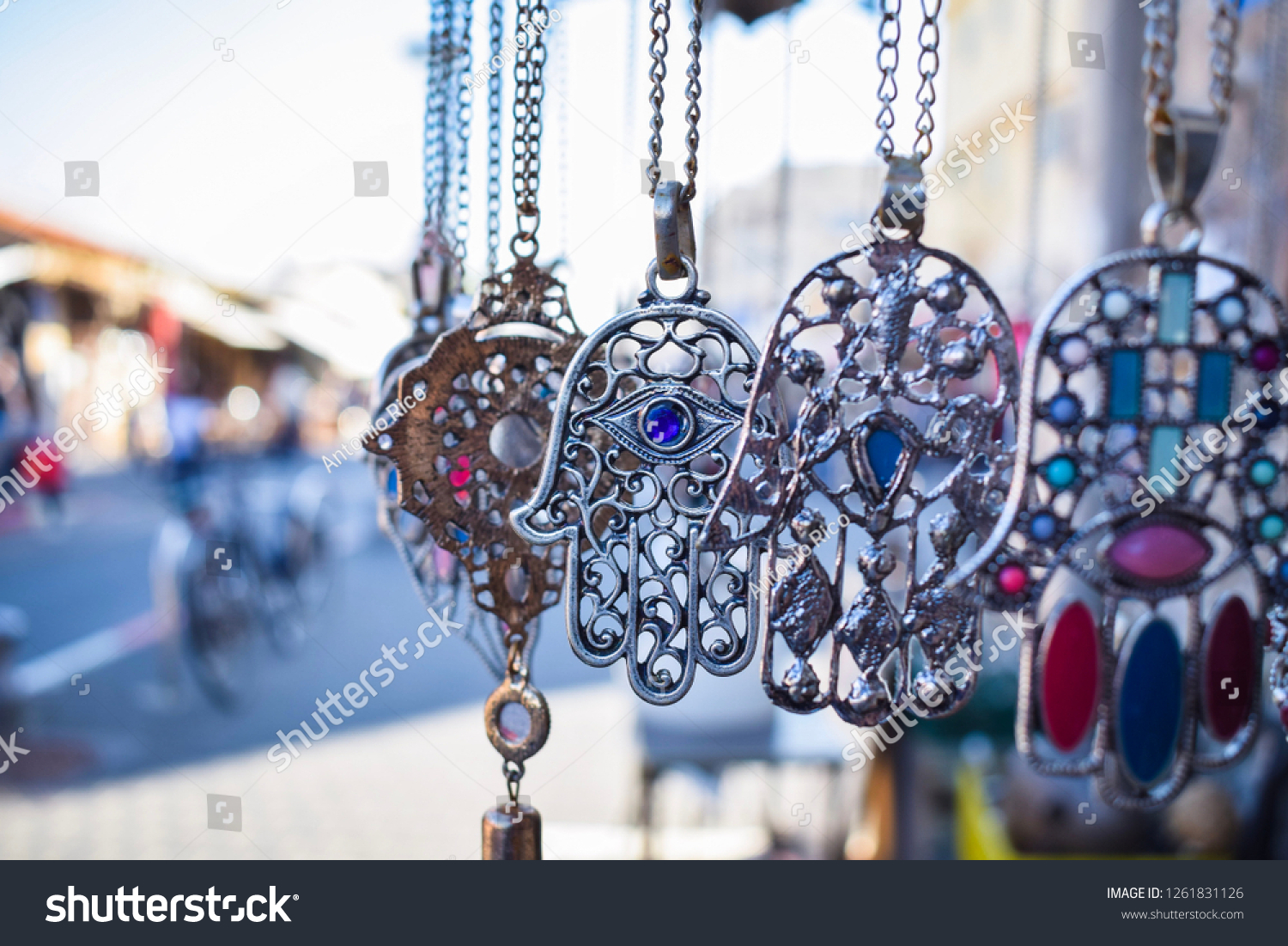 Close-up of Hamsa, also known as Fatima Hand or Hand of God necklace,  pending on a flea market in Tel Aviv-Jaffa, Israel. Metal protection amulet. #1261831126