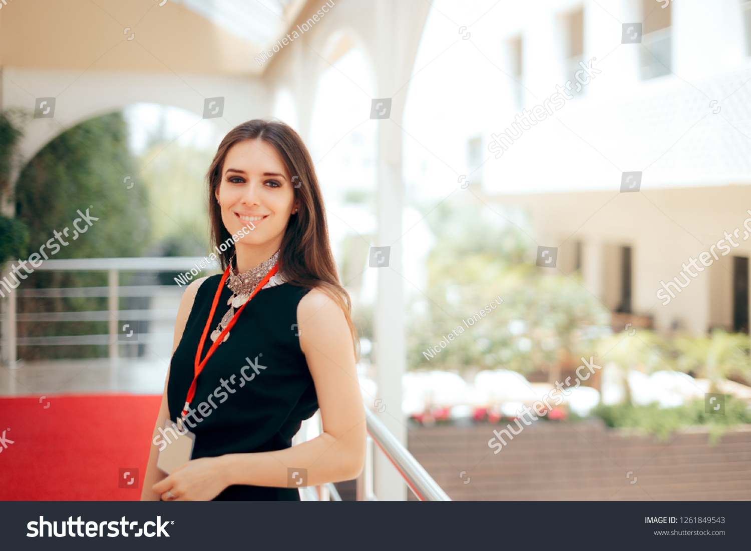 Event Planner Coordinator PR Specialist Employee at Formal Event 
Authorized manager wearing a badge welcoming guests at hotel entrance
 #1261849543