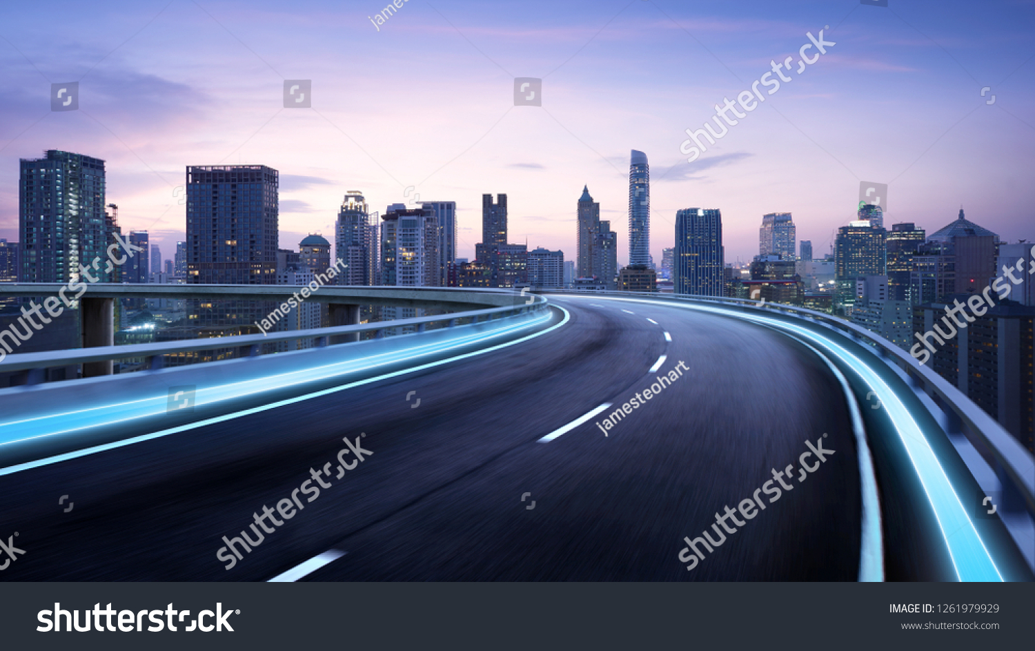 Curvy flyover highway moving forward road with Bangkok cityscape evening scene view . motion blur effect apply #1261979929