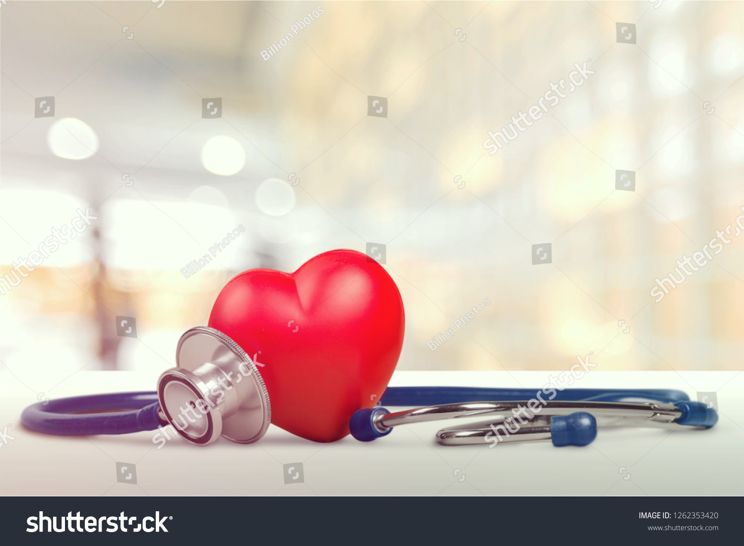 One single alone red heart love shape hand exercise ball with bandage MD medical doctor physician's stethoscope white wood background: Hospital life insurance concept: World heart health day idea #1262353420