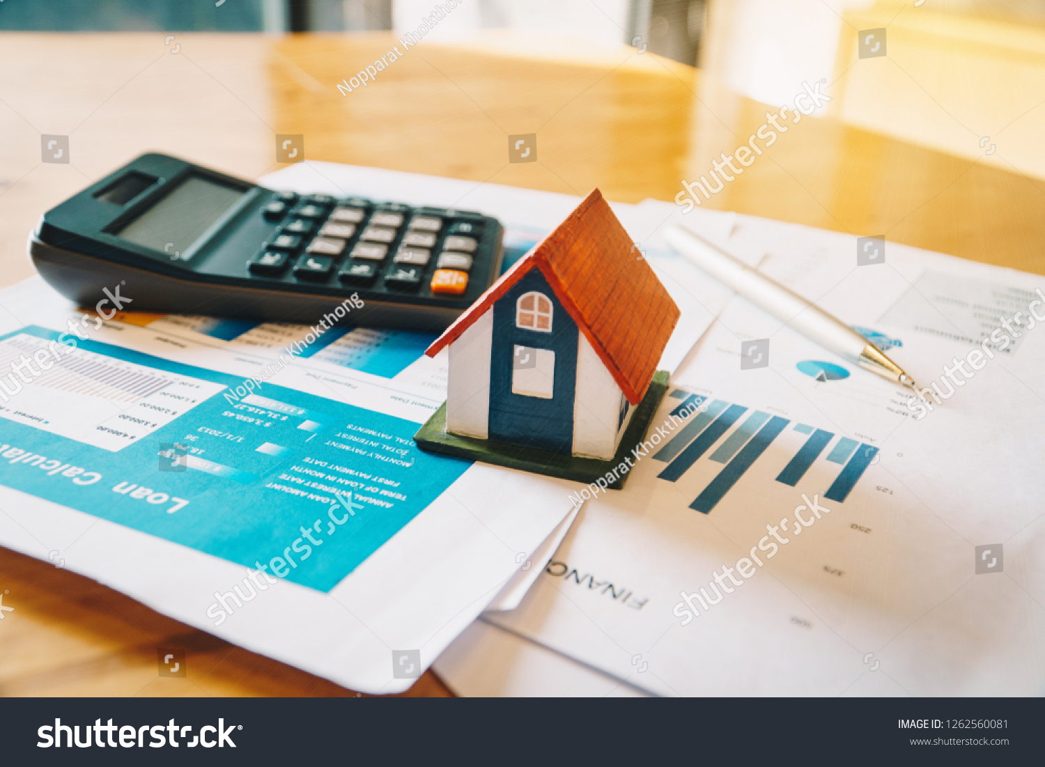 House model,Calculator and financial chart  on wooden table. Investment to buying property concept. #1262560081