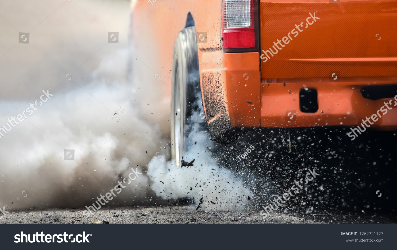 Drag racing car burns rubber off its tires in preparation for the race #1262721127