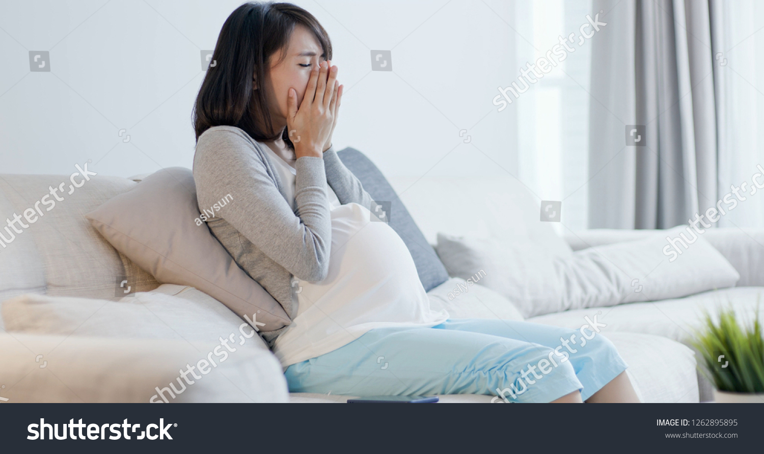 pregnant woman look smart phone and feel depression at home #1262895895