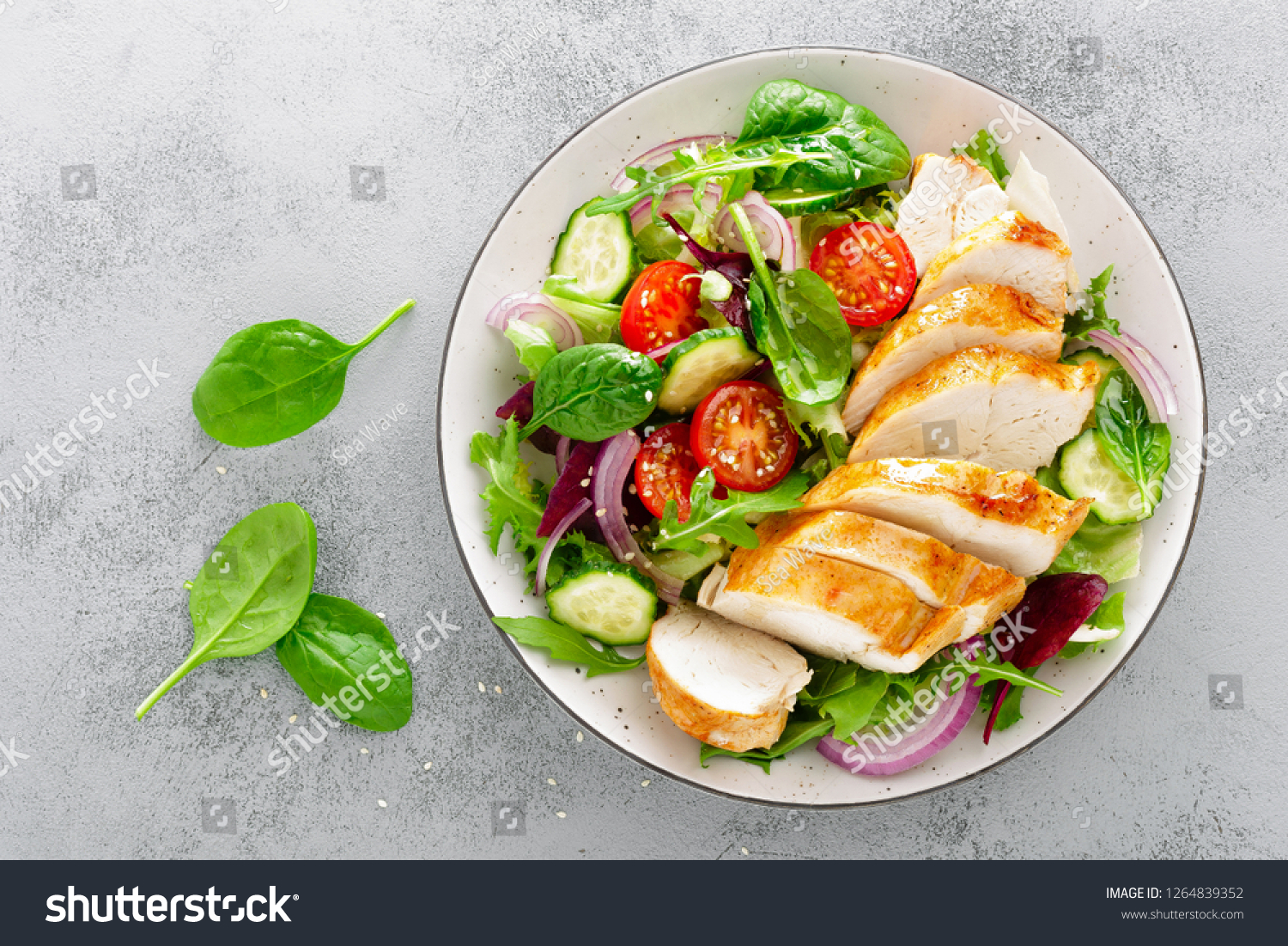 Grilled chicken breast, fillet and fresh vegetable salad of lettuce, arugula, spinach, cucumber and tomato. Healthy lunch menu. Diet food. Top view #1264839352
