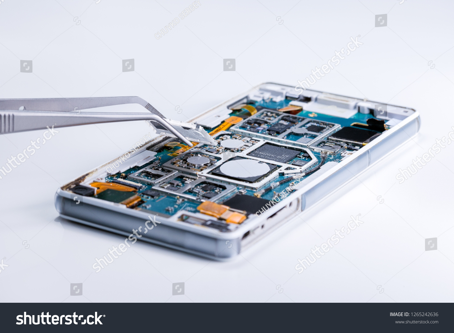 Repairing the smartphone's motherboard in the lab. the concept of computer hardware, mobile phone, electronic, repairing, upgrade and technology. #1265242636