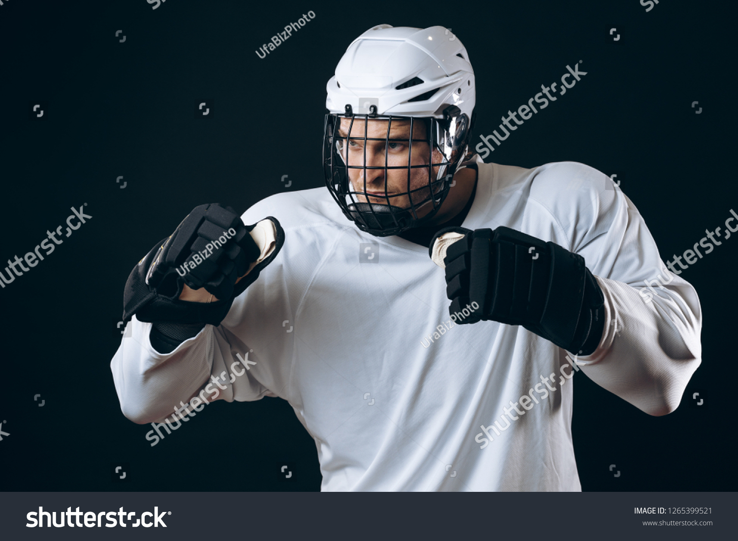 Emotional outraged ice-hockey player man gestures angrily, being provoked with the enemy, standing in fight pose. Sport, Negative emotions and rivalry concept #1265399521