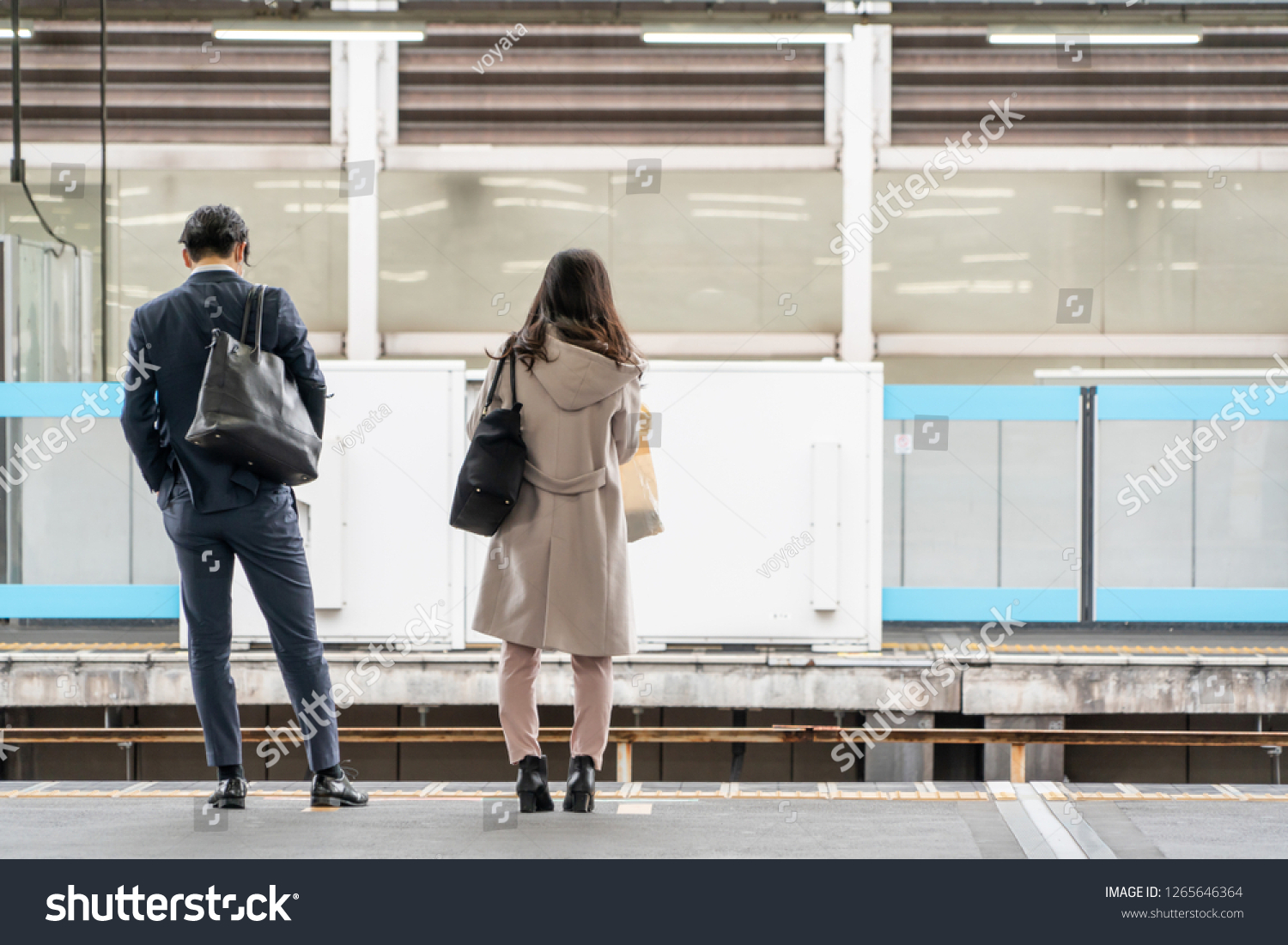 Asia Business concept for real estate and corporate construction - Asia business woman and man stand on train platform in background in Tokyo, Japan #1265646364