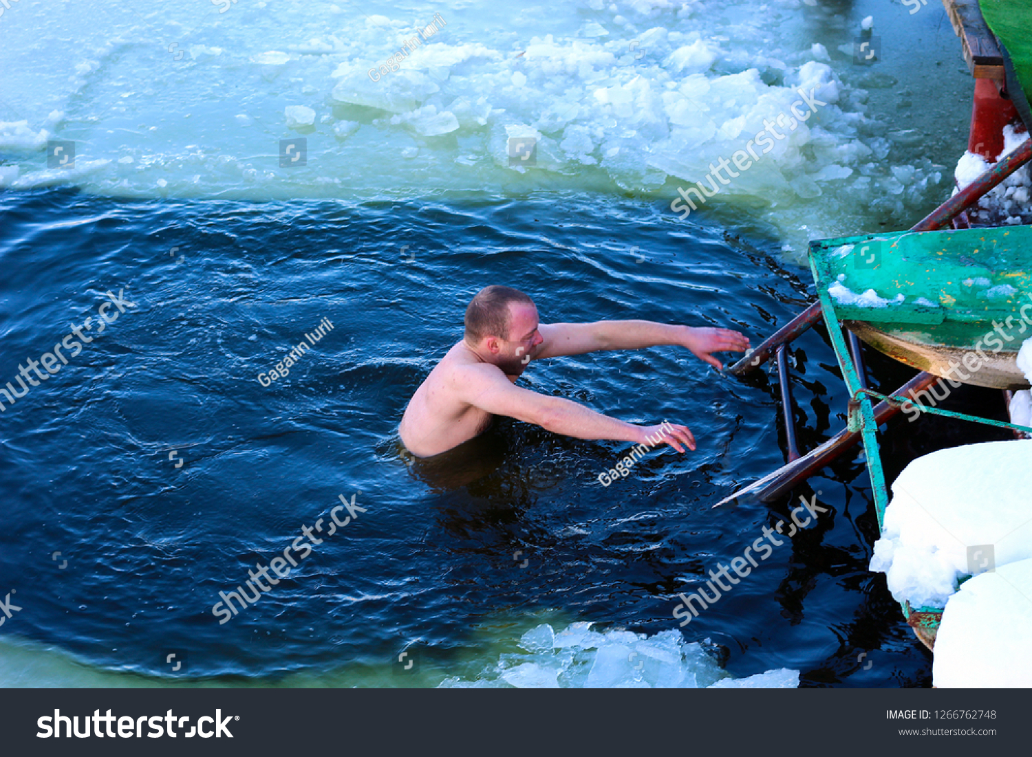 A man with a cry runs out of the ice-hole of the lake, a light motion blur as an artistic device to enhance the dynamics of the event. #1266762748