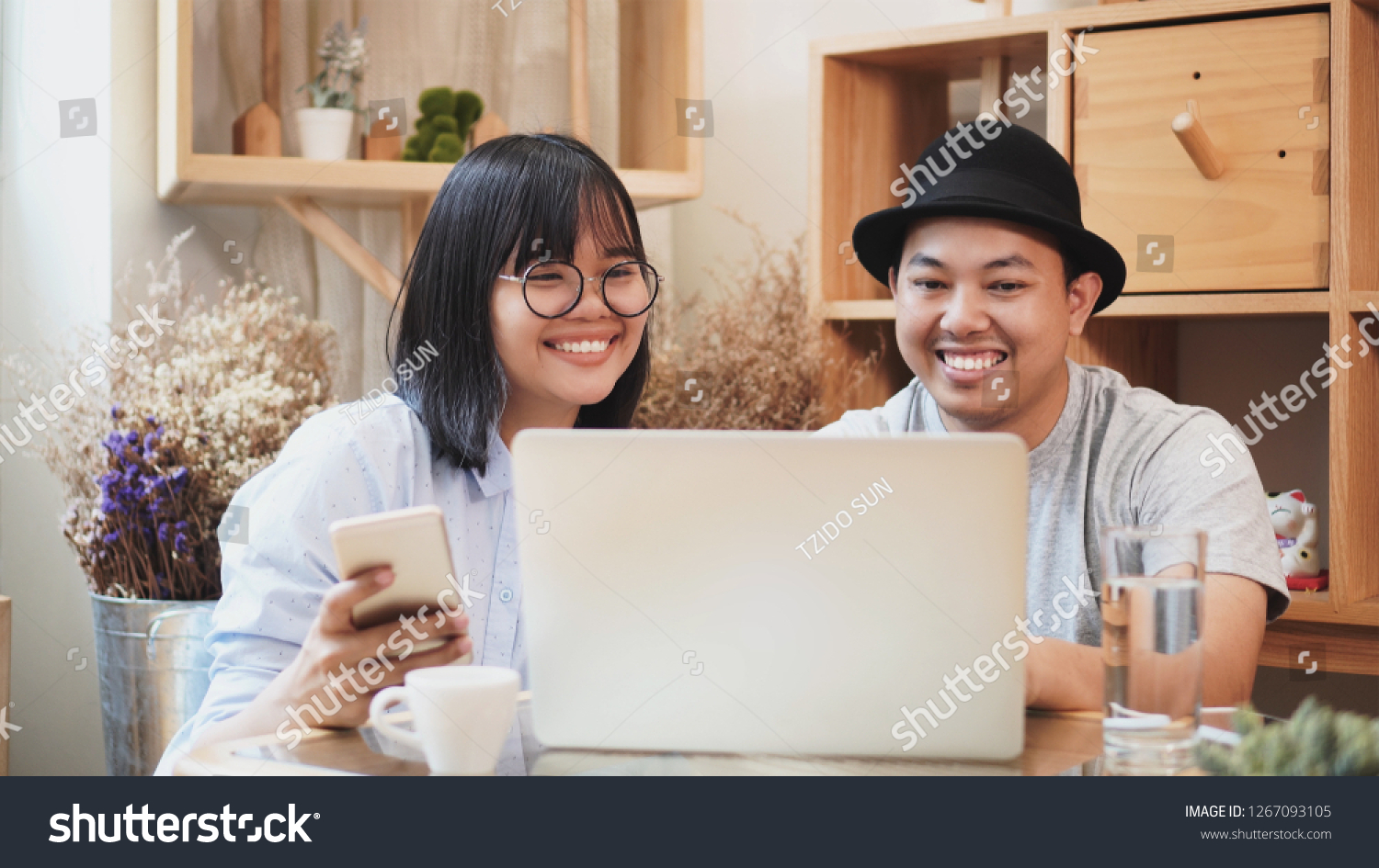 Asian young workmate freelance in casual suit sitting to work together with technology laptop in modern co-working space, couple and colleague concept #1267093105