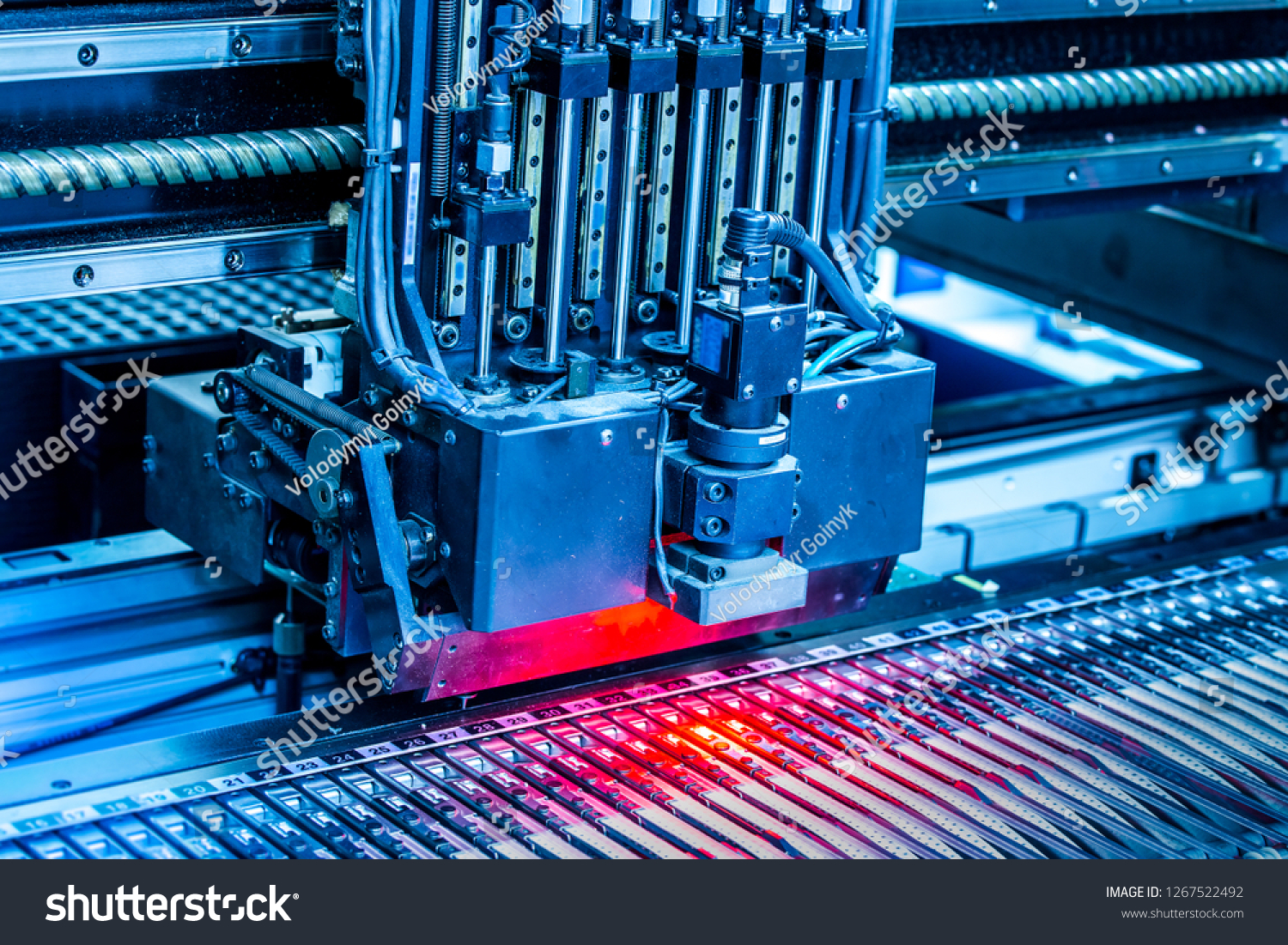 Close-up surface-mounting machine in progress. SMT (surface-mount technology) is a method for producing electronic circuits. Components are placed directly onto the surface of printed circuit boards. #1267522492