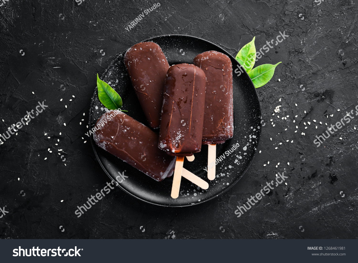 Chocolate ice cream on a stick. On a black background. Top view. Free copy space. #1268461981