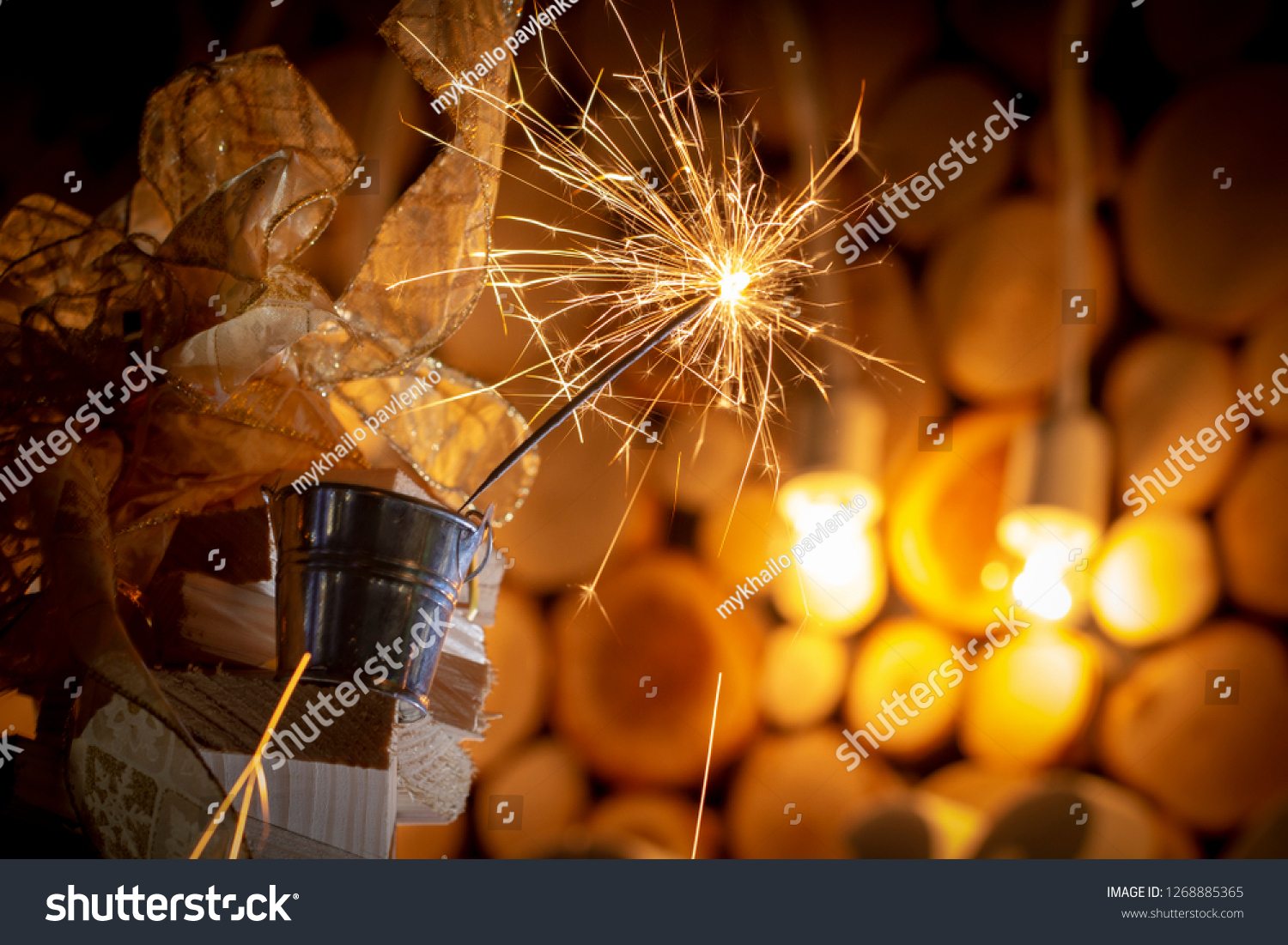 Rustic wooden wall with a sparkler and golden bokeh Christmas concept #1268885365