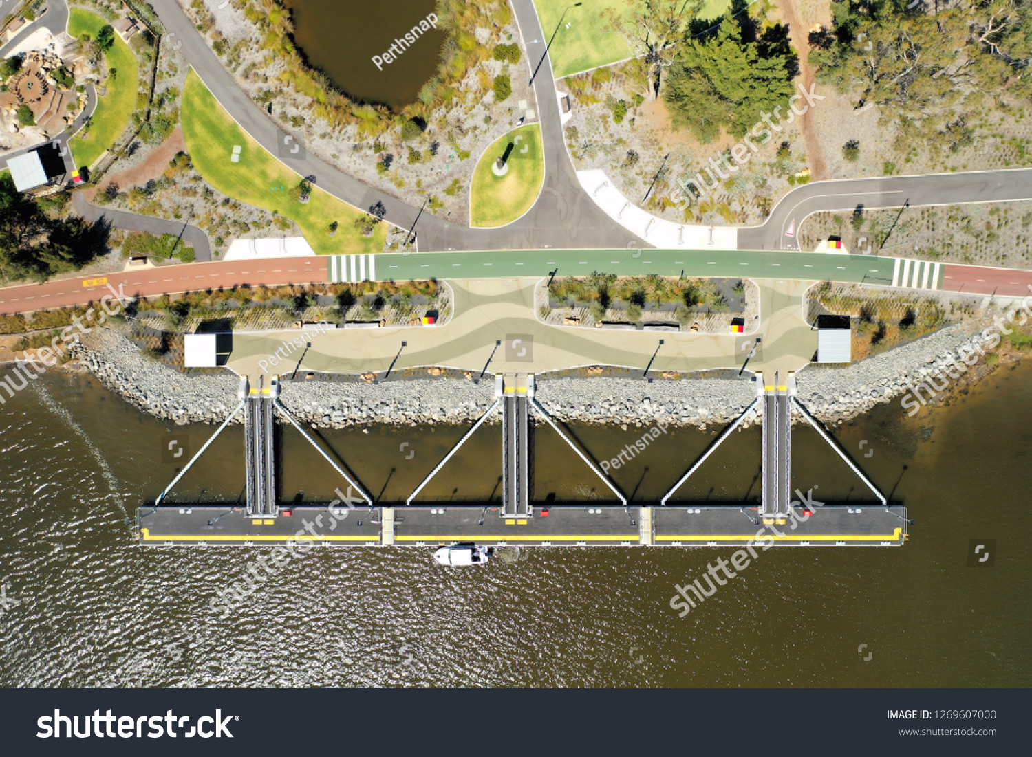 Aerial view of a floating jetty (Burswood Jetty) with the river below and colourful walkway and park behind in Perth Western Australia #1269607000