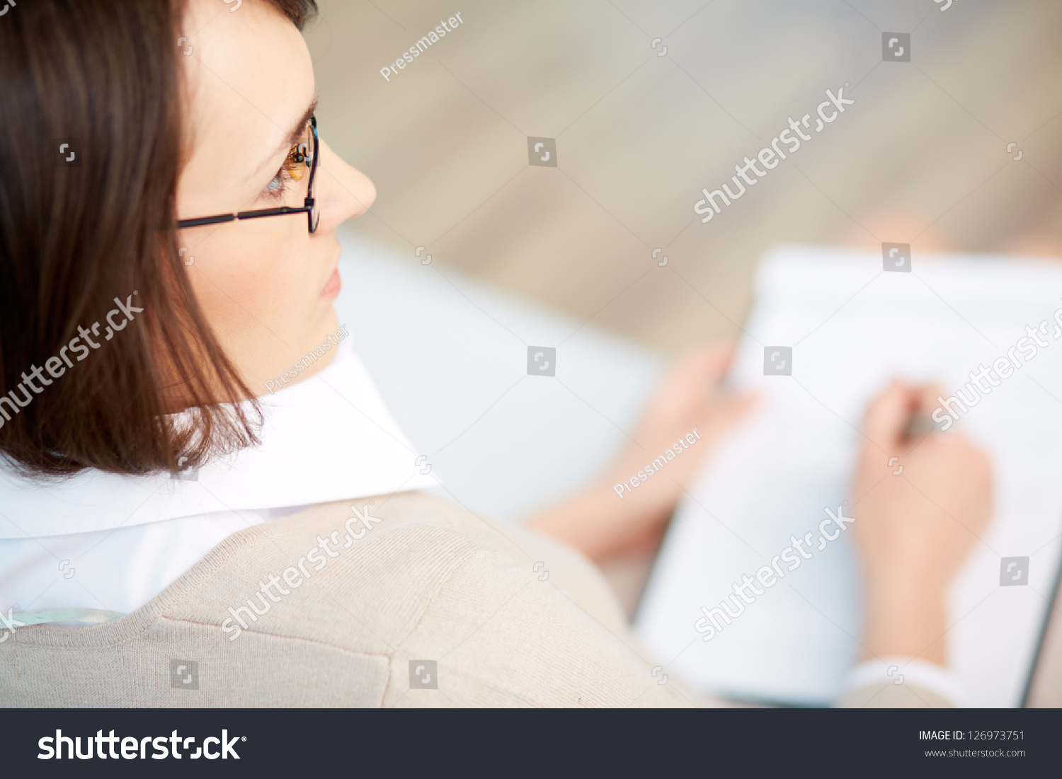 Professional psychiatrist keeping record during therapy session #126973751