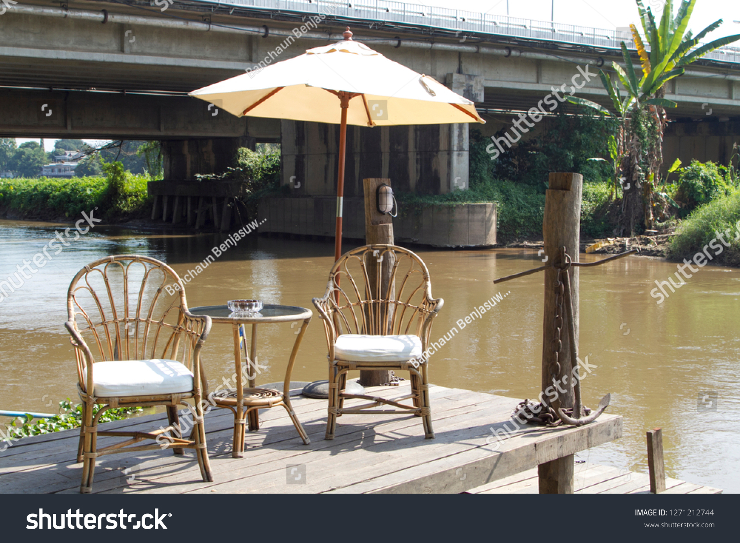 Two classic vintage chairs, table and white umbrella near river #1271212744