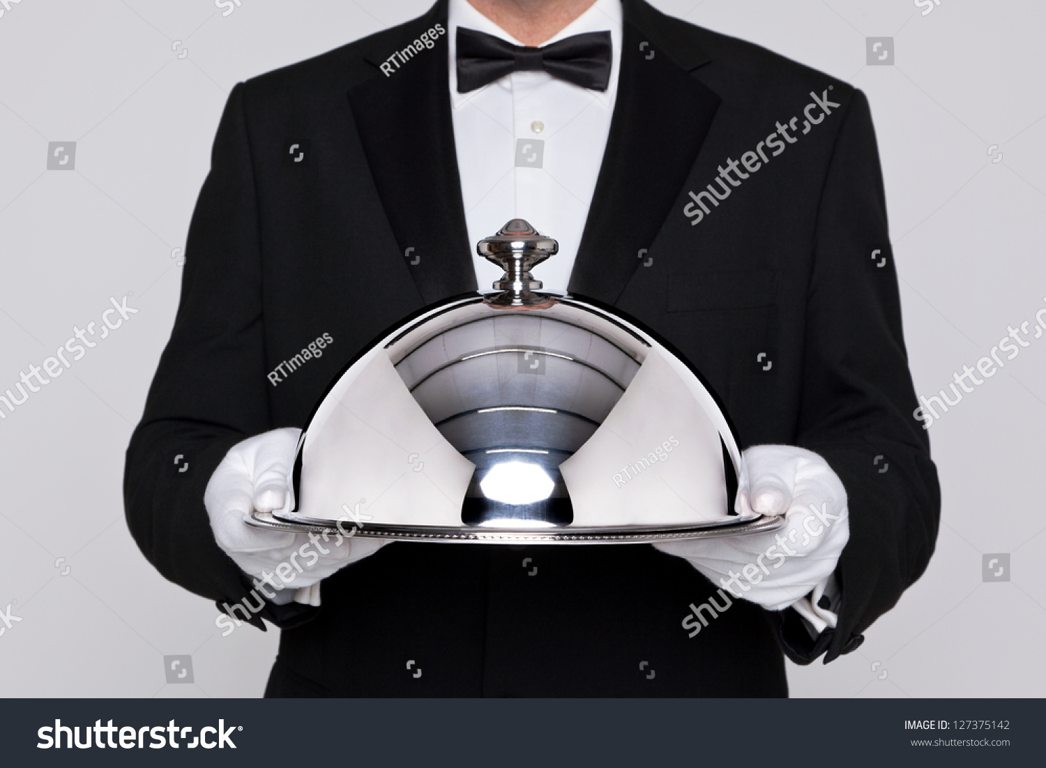 Waiter serving a meal under a silver cloche or dome #127375142