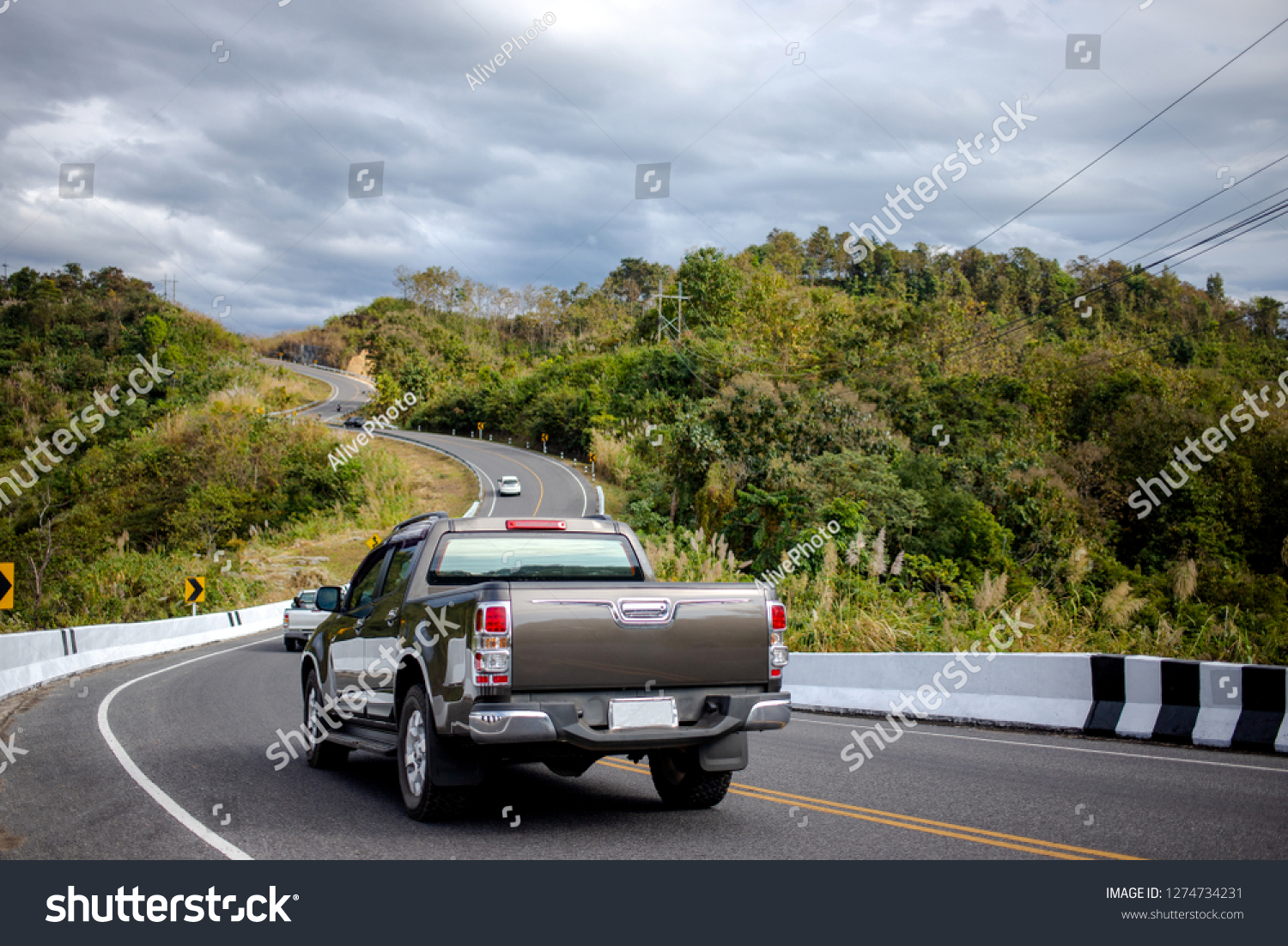 Cars running on the beautiful road along the mountain, Rear view of pickup truck on wavy road #1274734231