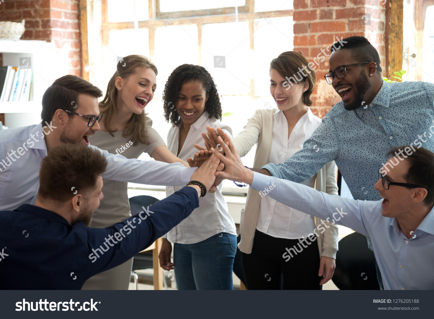 Happy diverse colleagues team people give high five together celebrate great teamwork result motivated by business success victory loyalty unity concept, good corporate relations and teambuilding #1276205188