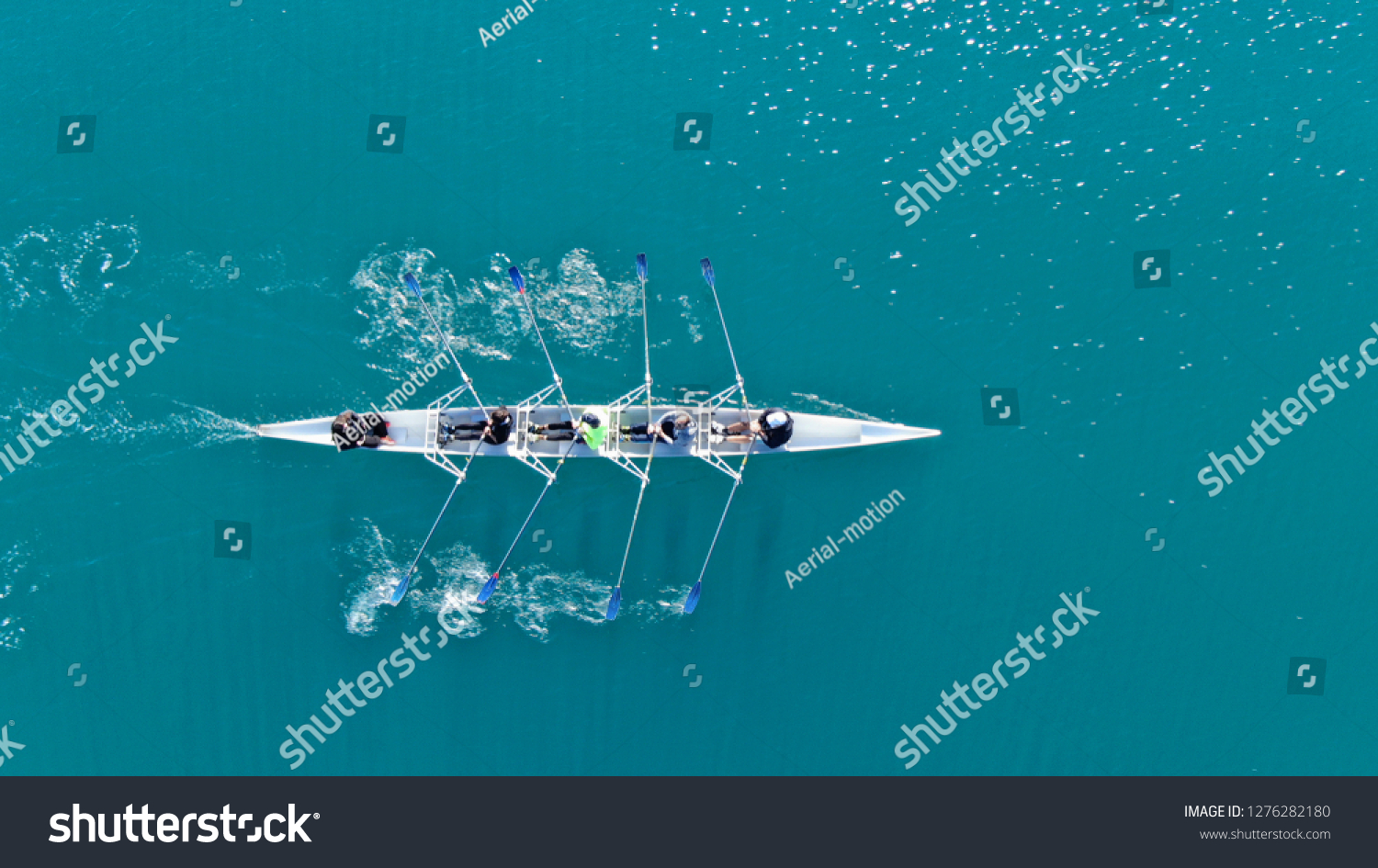 Aerial drone top down photo of sport canoe operated by team of young women in emerald calm sea waters #1276282180