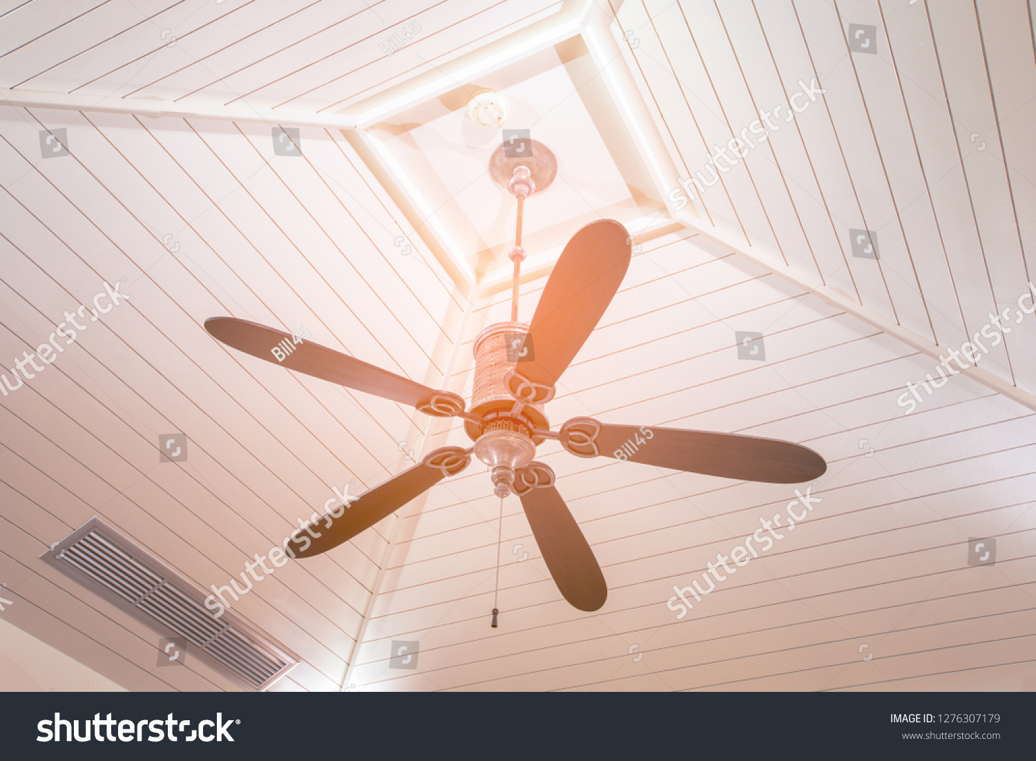 Vintage black ceiling fan with strip wood ceiling in hotel #1276307179