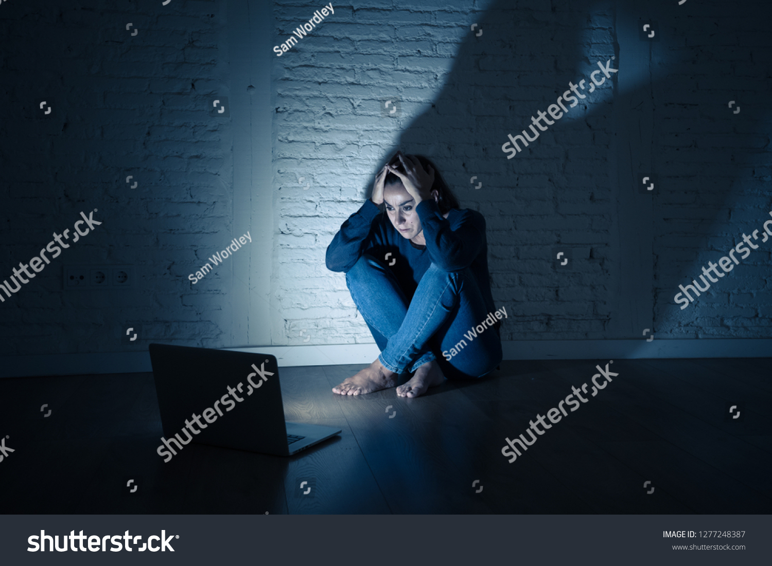 Sad and scared female Young woman with computer laptop suffering cyberbullying and harassment being online abused by stalker or gossip feeling desperate and humiliated in cyber bullying concept. #1277248387
