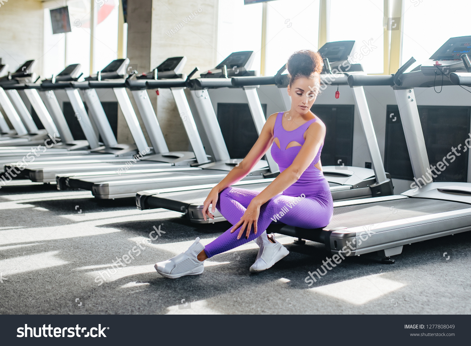 Sport world. Young fitness girl in sport wear relaxing on the treadmill in the gym, Exercise working out with copy space. Runnig machine #1277808049