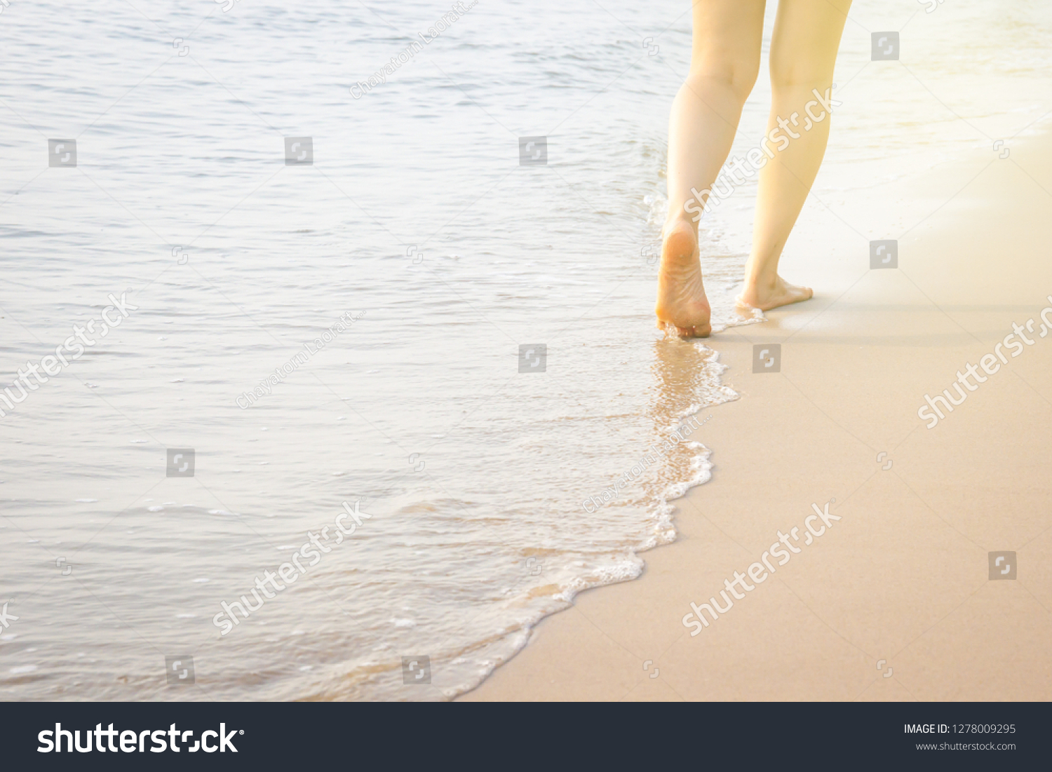 Girl walking along the beach during the sunrise. #1278009295