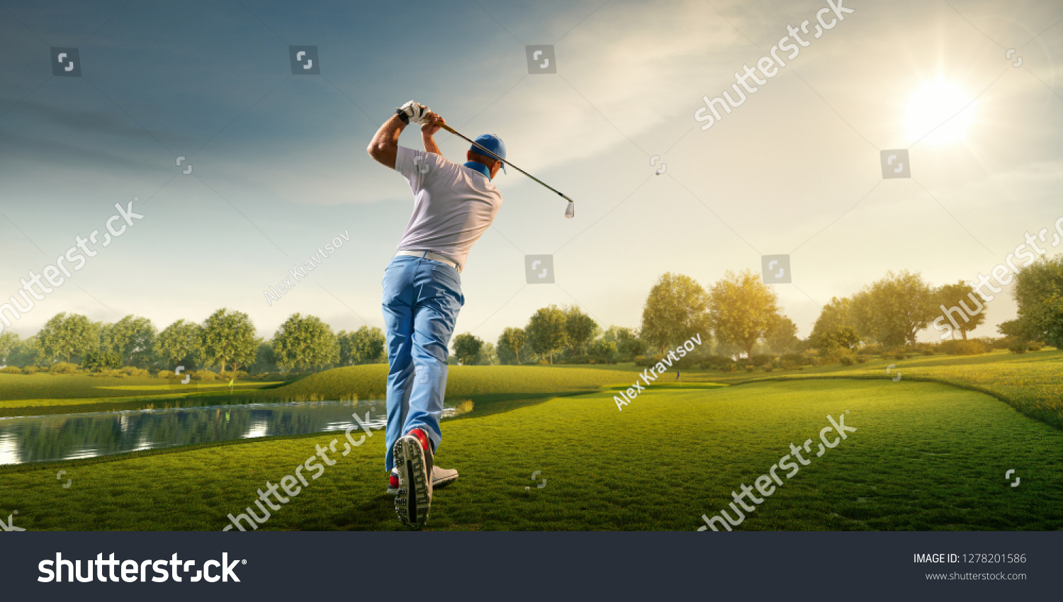 Male golf player on professional golf course. Golfer with golf club taking a shot #1278201586