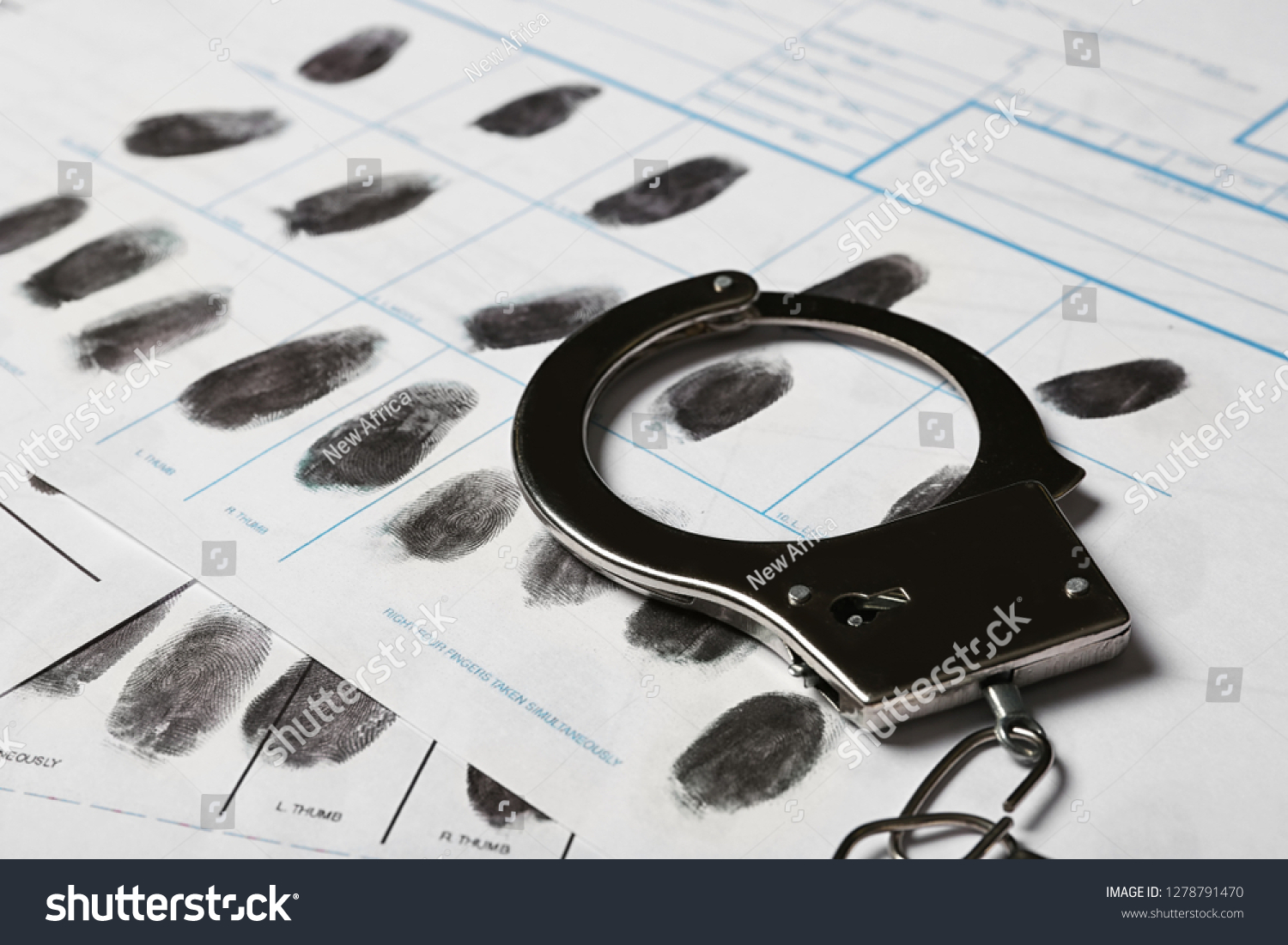 Police handcuff and criminal fingerprints card, closeup #1278791470