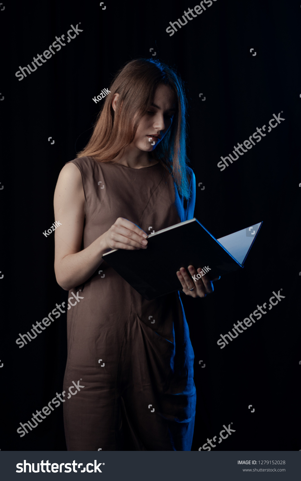 Girl Actress on stage plays emotions in blue theatrical light #1279152028