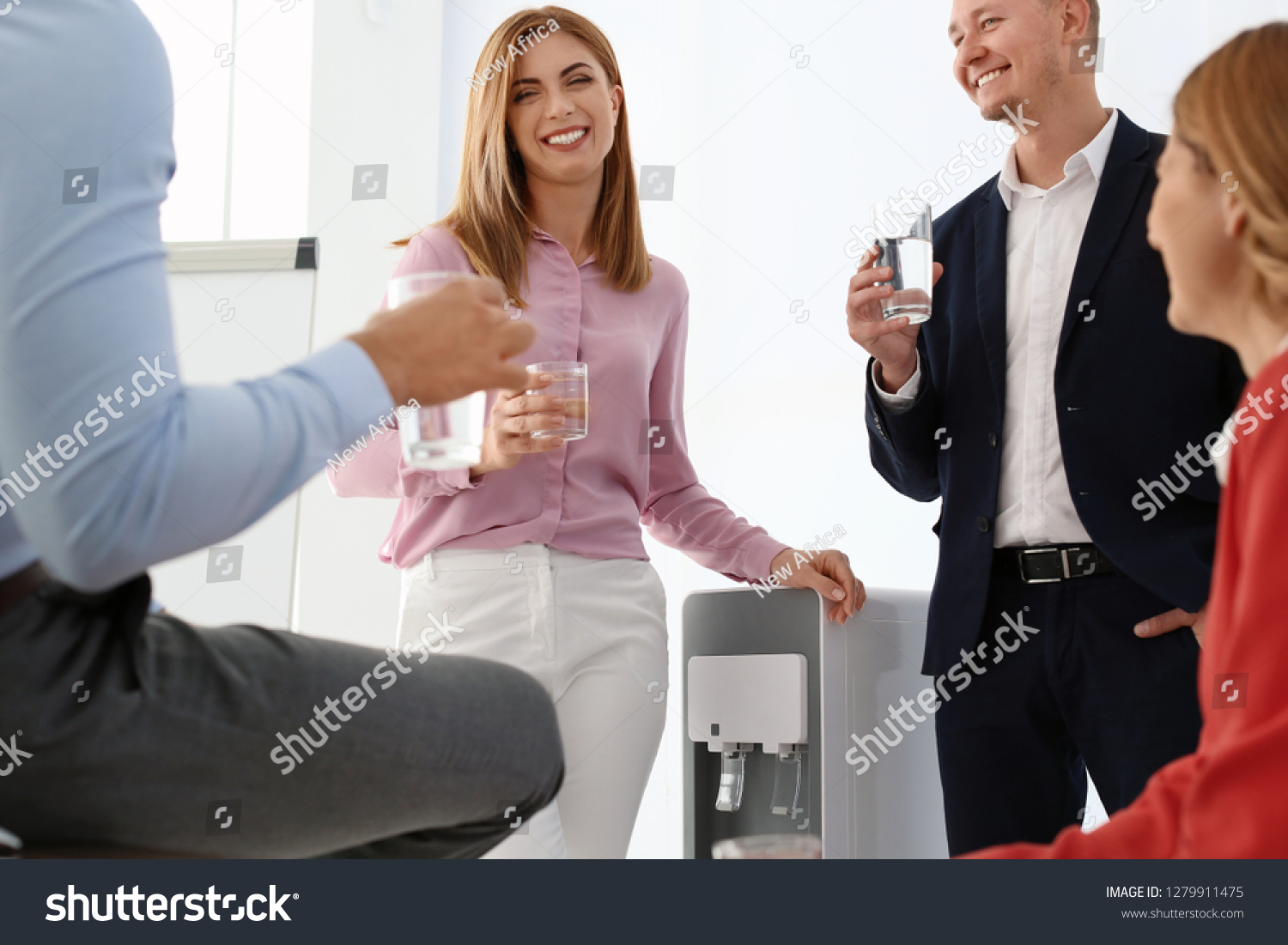 Co-workers having break near water cooler at workplace #1279911475