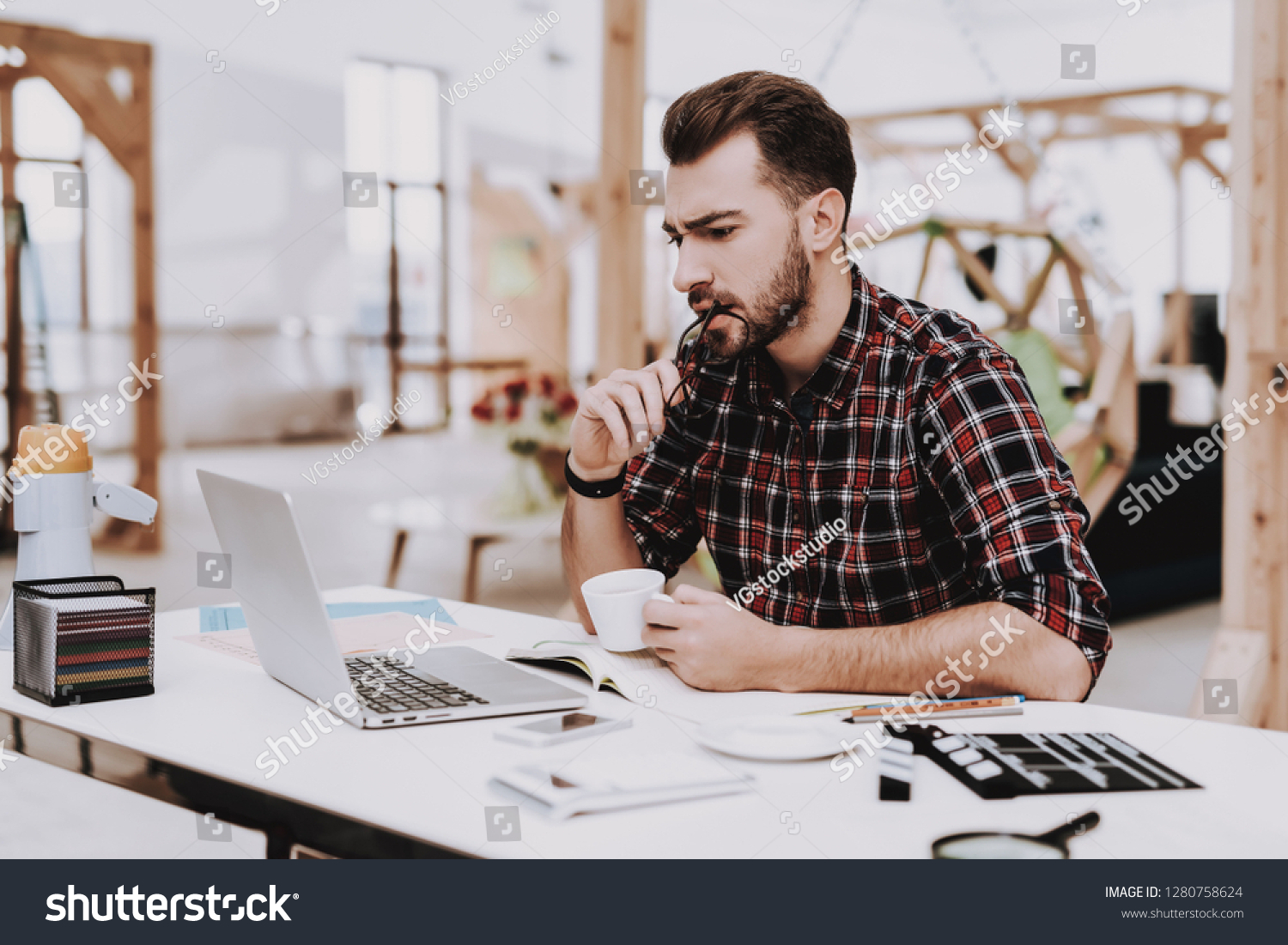 Laptop Screen. Cup of Coffee. Desk. Workplace. Mobile Phone. Young Male. Businessman. Creative Worker. Creates Ideas. Project. Sit. Brainstorm. Work. Office. Creative Worker. Inspiration. Eyeglasses. #1280758624