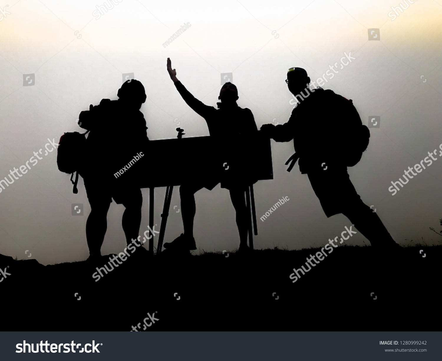 silhouette of tourist hiker acting on top of mountain #1280999242