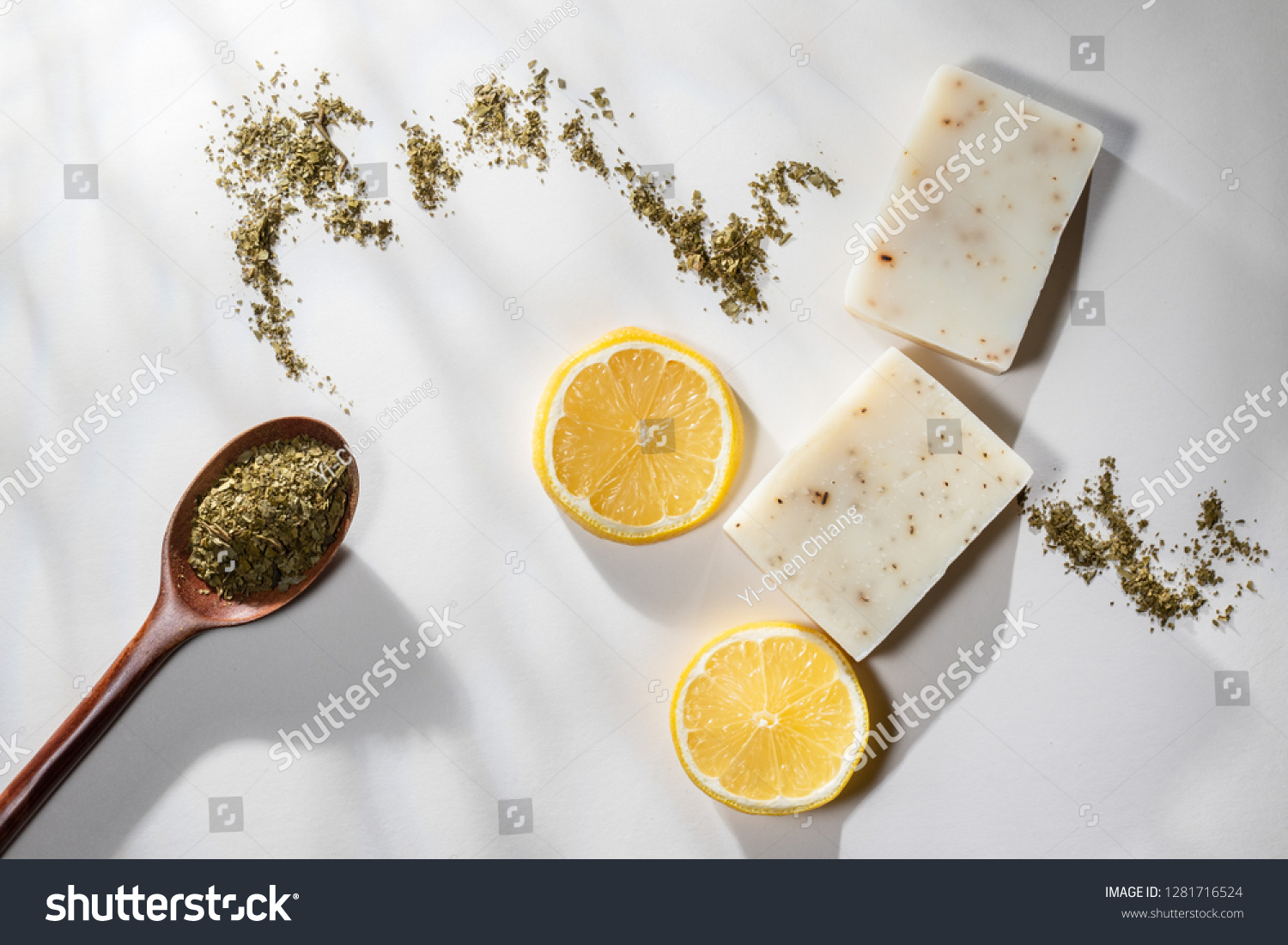 Flat lay of two handmade lemon tea bar soaps with a spoonful of tea leaves and lemon slices #1281716524