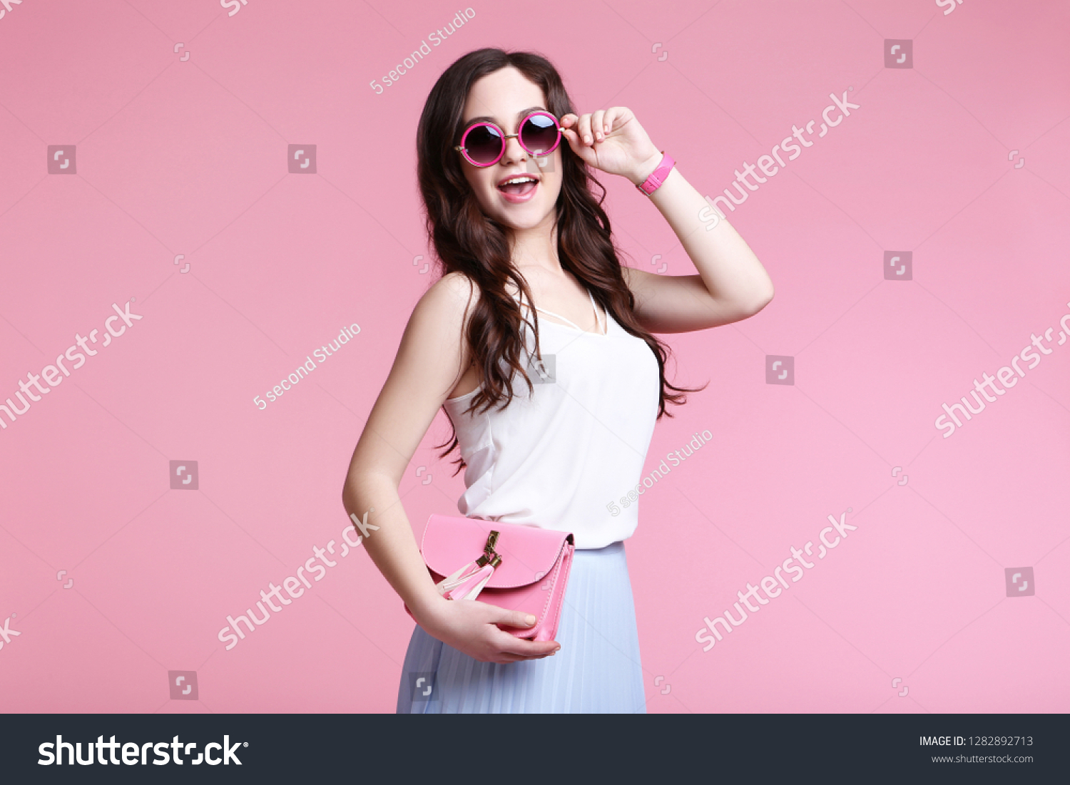 Beautiful young woman with handbag on pink background #1282892713