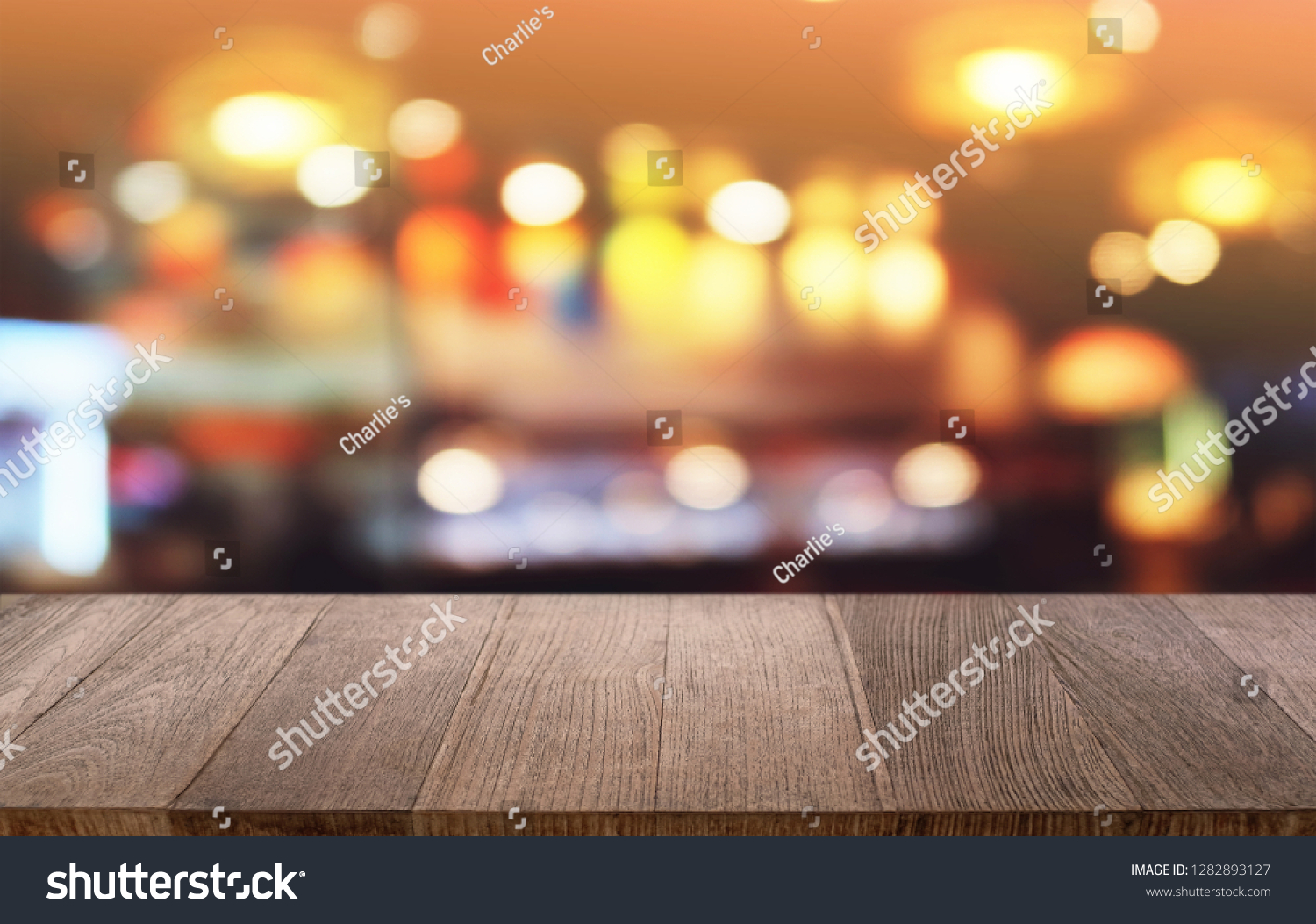 Empty dark wooden table in front of abstract blurred bokeh background of restaurant . can be used for display or montage your products.Mock up for space #1282893127